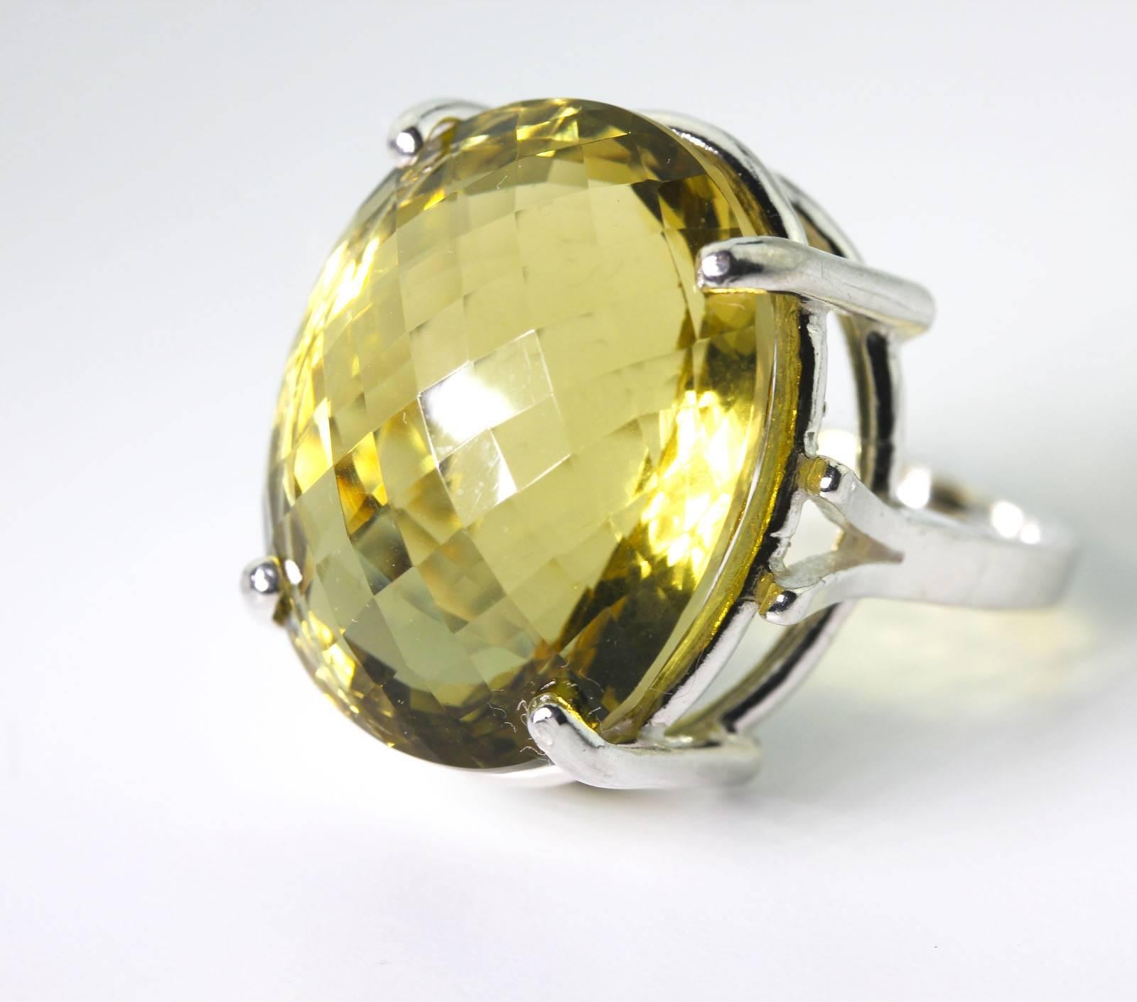 Huge Brilliant eye clean checkerboard cut 31.3 carat Brasilian Lemon Quartz set in Sterling Silver ring size 7 (sizable for free).  This is fabulous in the evenings when it really shows itself off.   