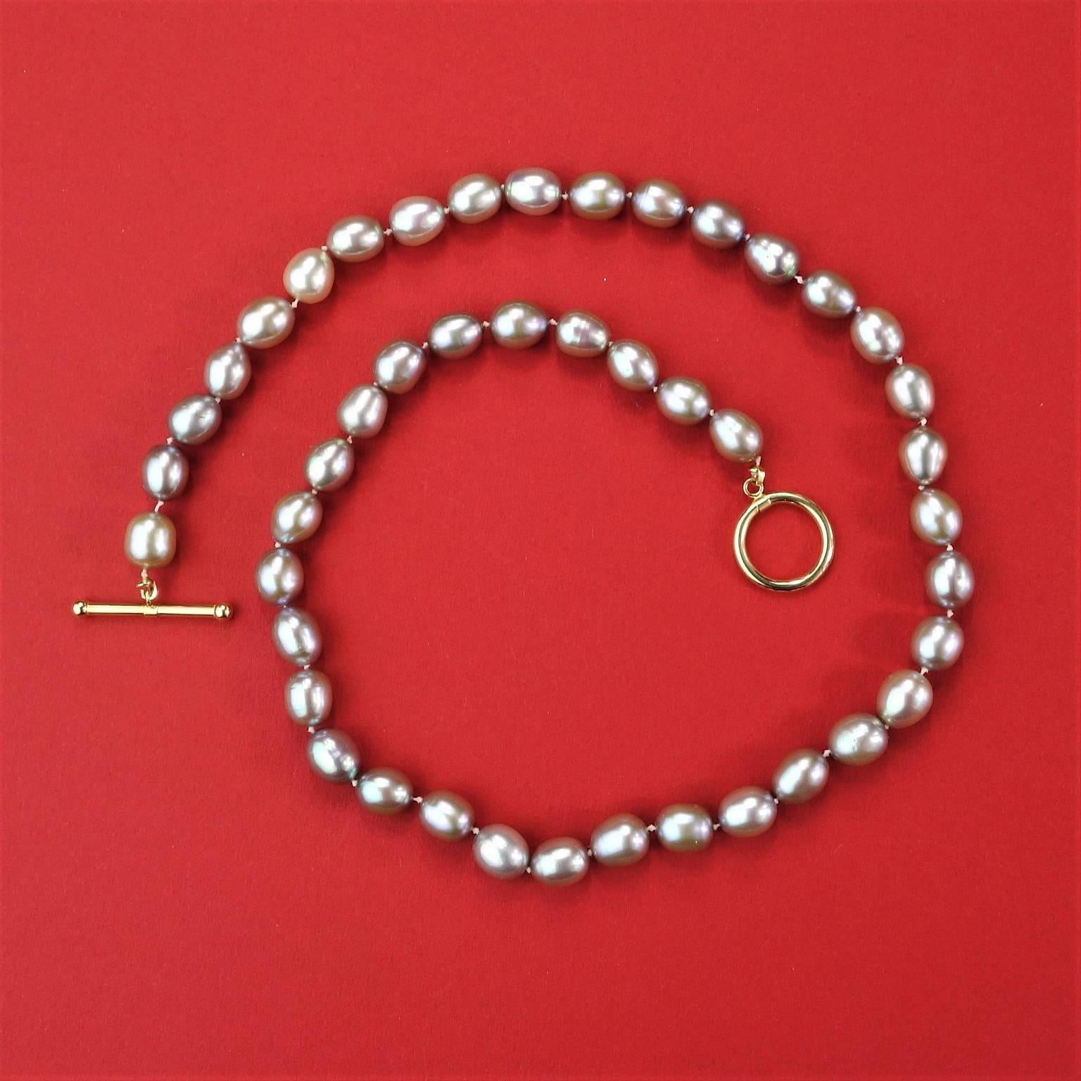 Necklace of iridescent oval (6-7mm) gray pearls with pink and mauve tones. The necklace is hand knotted and secured with a toggle clasp of 14kt yellow gold. The gorgeous necklace is 18 inches long and can be worn all day, every day. Pearl is the