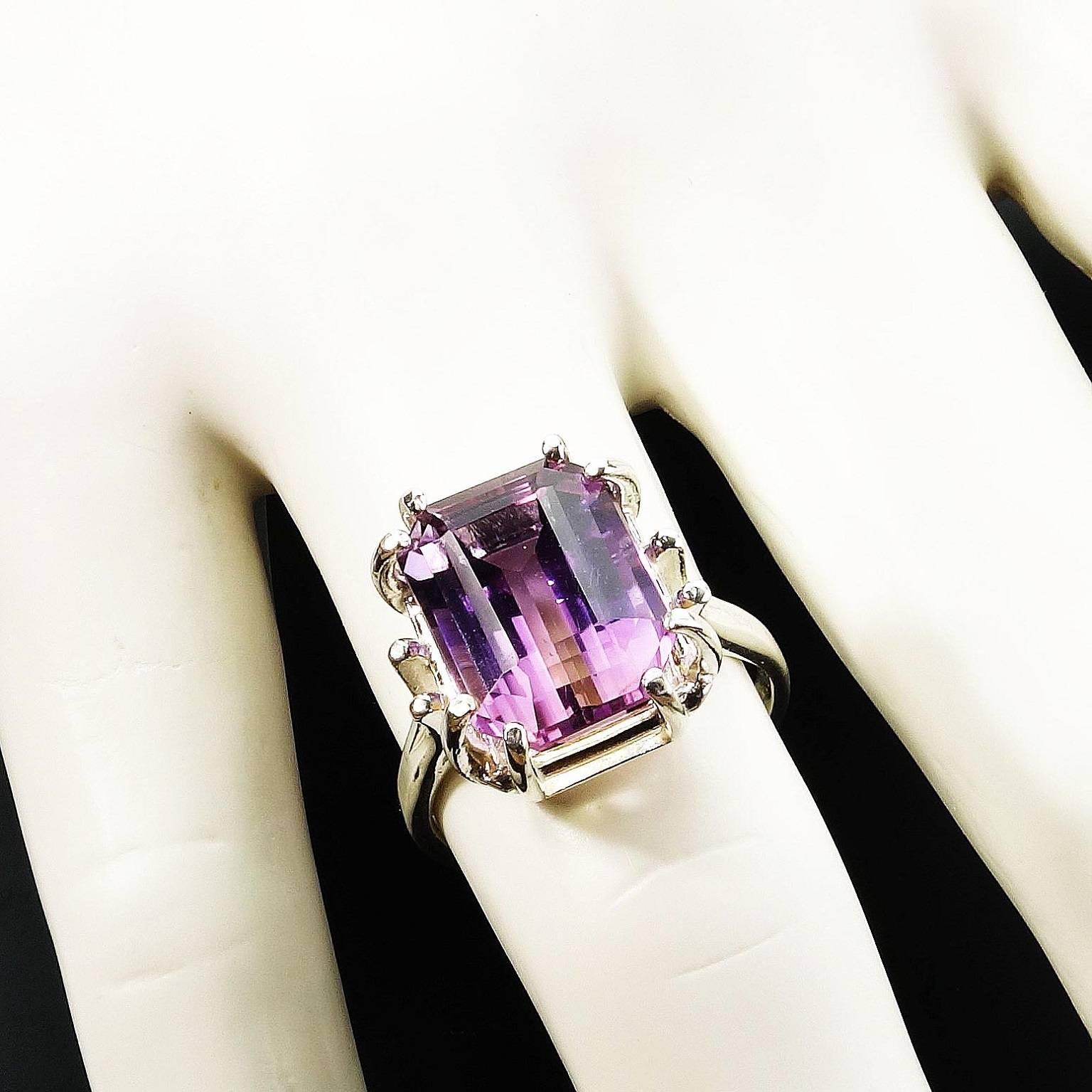 Lots of Sterling Silver enhances this lovely, custom made Brazilian Ametrine (part Amethyst and part Citrine) ring. The emerald cut Ametrine is set is a fancy eight prong setting, two at each corner, with a split shank.  Two more half prongs rise up