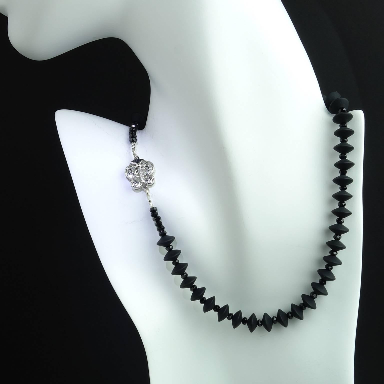 Elegant choker necklace of frosted black onyx and sparkling faceted black spinel. The elongated rondels of frosted black onyx are 10mm. They alternate with sparkling black spinels which are 4mm. The delicate pieced silvertone butterfly box clasp