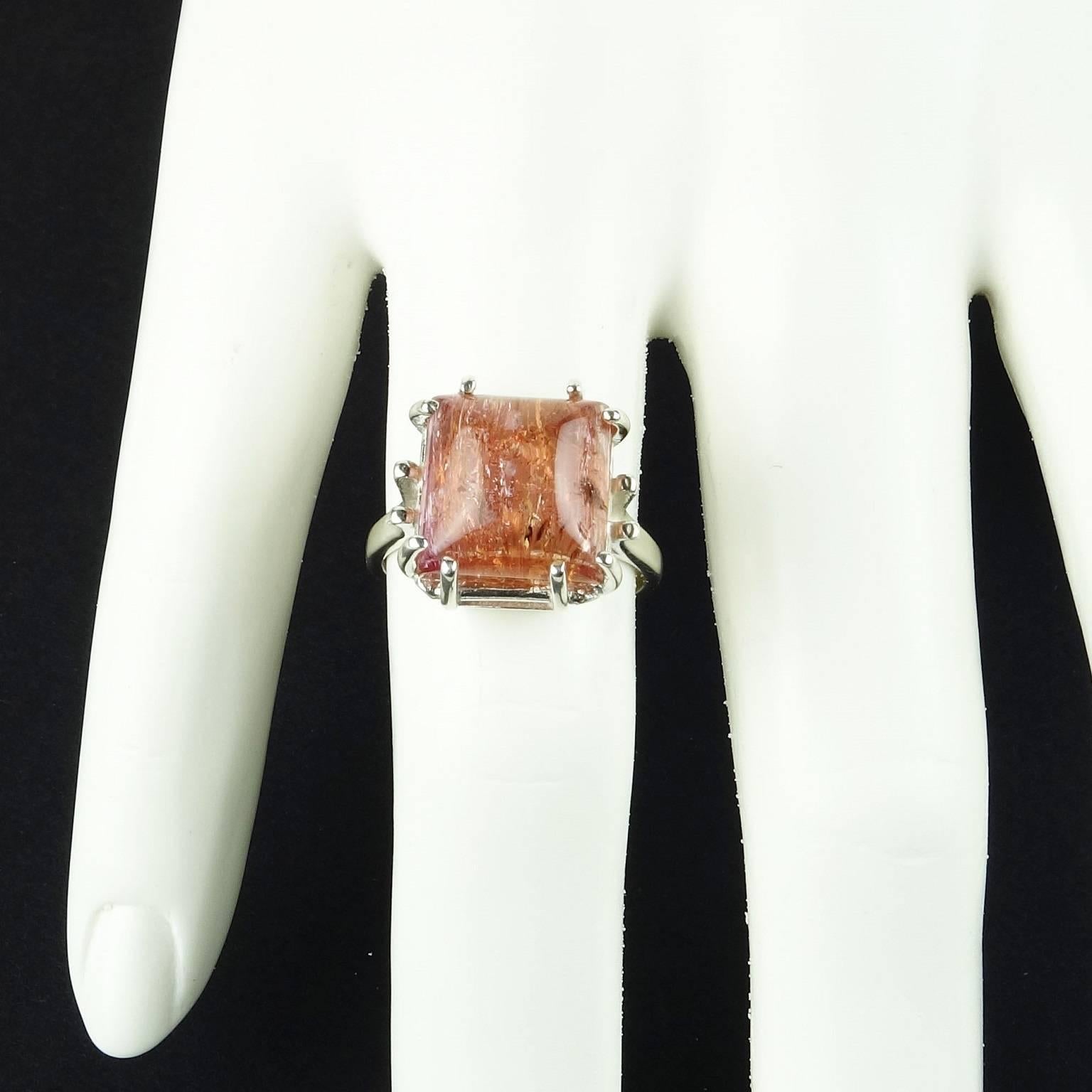 Glowing pinkish/orange Imperial Topaz square cabochon set in eight prong Sterling Silver ring.  The color in this gemstone is truly lovely.  The typical Imperial Topaz inclusions enhance the gemstone's sparkle.  It measures 11x11mm and weighs 10.03