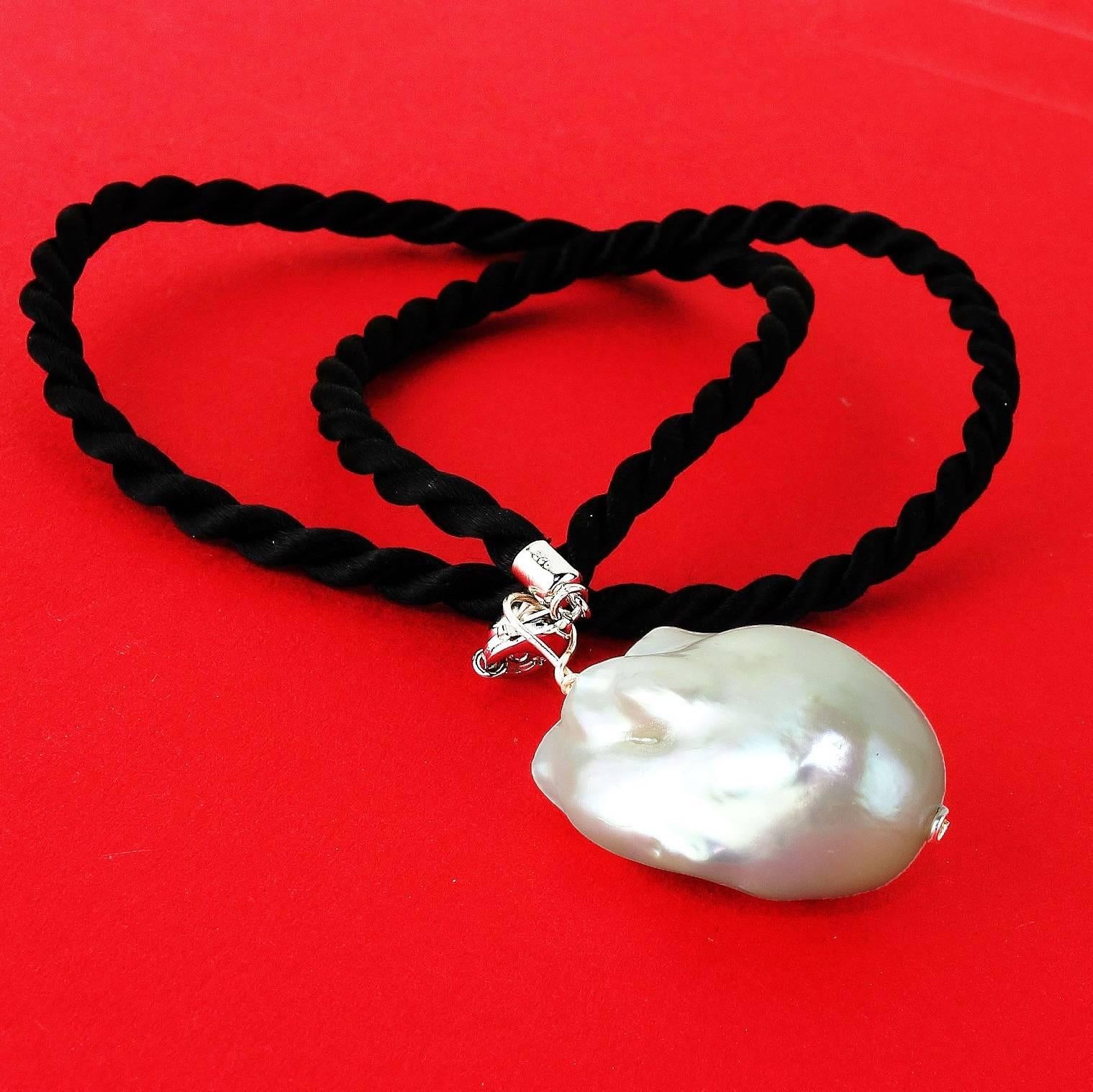 Magnificent one of a kind White Baroque Pearl Pendant on a black cord. The pearl is beautiful from all angles. This can be worn on the cord or a silver choker or other device. The black cord is 16.25 inches and closes with a lobster claw clasp. The