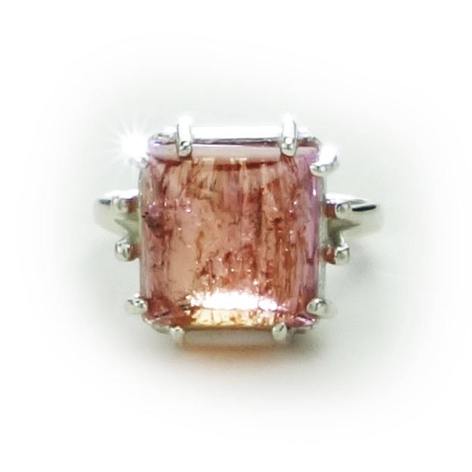 Glowing pinkish/orange Imperial Topaz square cabochon set in eight prong Sterling Silver ring.  The color in this gemstone is truly lovely.  The typical Imperial Topaz inclusions enhance the gemstone's sparkle.  It measures 11x11mm and weighs 10.03