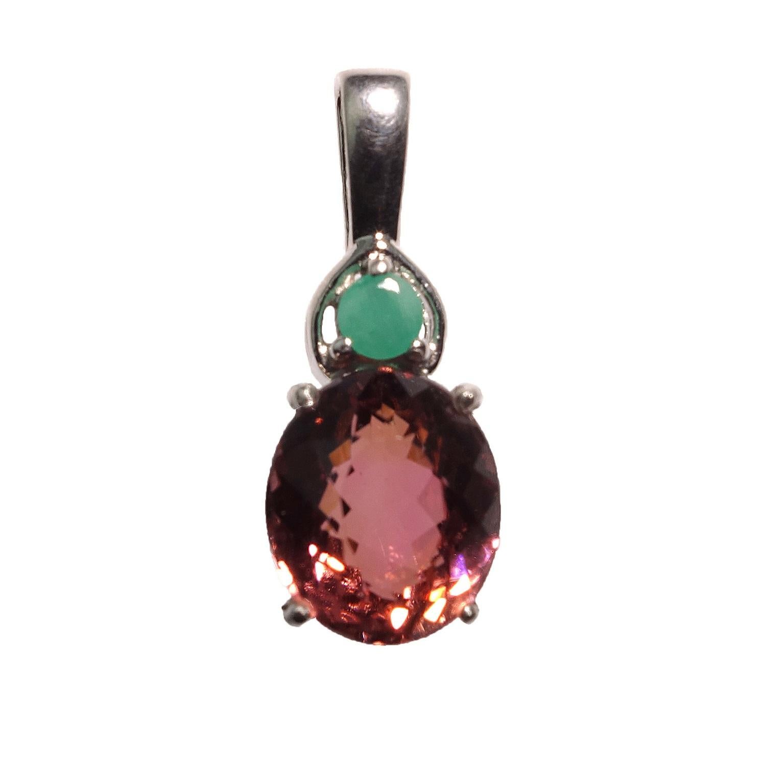 Unique, sparkling, peachy-brown (hint of pink) shade of oval Brazilian Tourmaline in Sterling Silver pendant. This lovely tourmaline is accented with a bright green round emerald. The gorgeous 10mm x 8mm tourmaline almost jumps out of the setting it