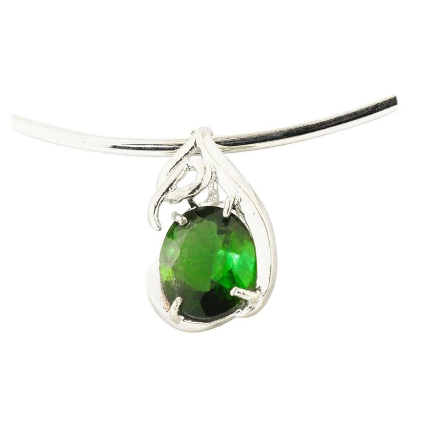 Brilliant glittering natural oval green 6 Carat Tourmaline (11 mm x 13 mm) set in a lovely sterling silver pendant that hangs approximately  one inch long.  Spectacular optical effect in the Tourmaline exhibits brilliant reflections and highlighted
