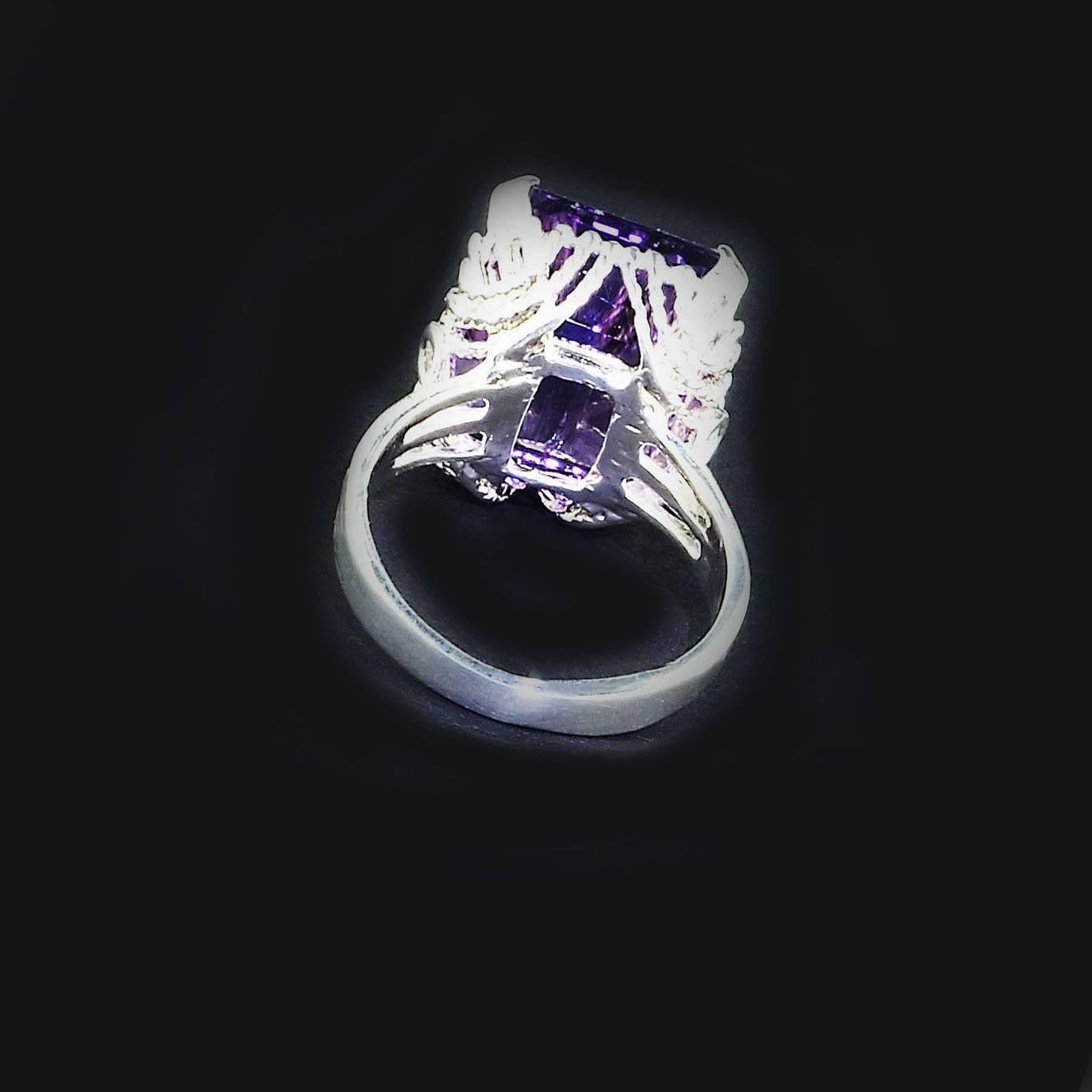 Custom made, bright and sparkling, medium tone Brazilian Amethyst ﻿in a delightful setting of a twisted rope basket in rhodium dipped Sterling Silver ring.  The 14.46 carat emerald cut Brazilian Amethyst comes straight from our favorite supplier in