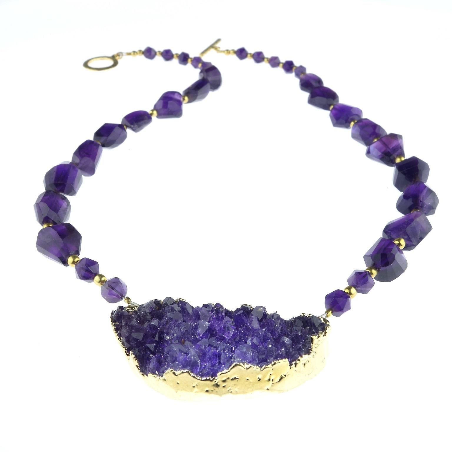 Sunning Amethyst Druzy Focal on rough cut and polished Amethyst necklace. The Amethyst Druzy is bezeled with electroplated gold and the Amethysts in the necklace are enhanced with goldtone accents.  The 20.50 inch necklace in secured with a gold
