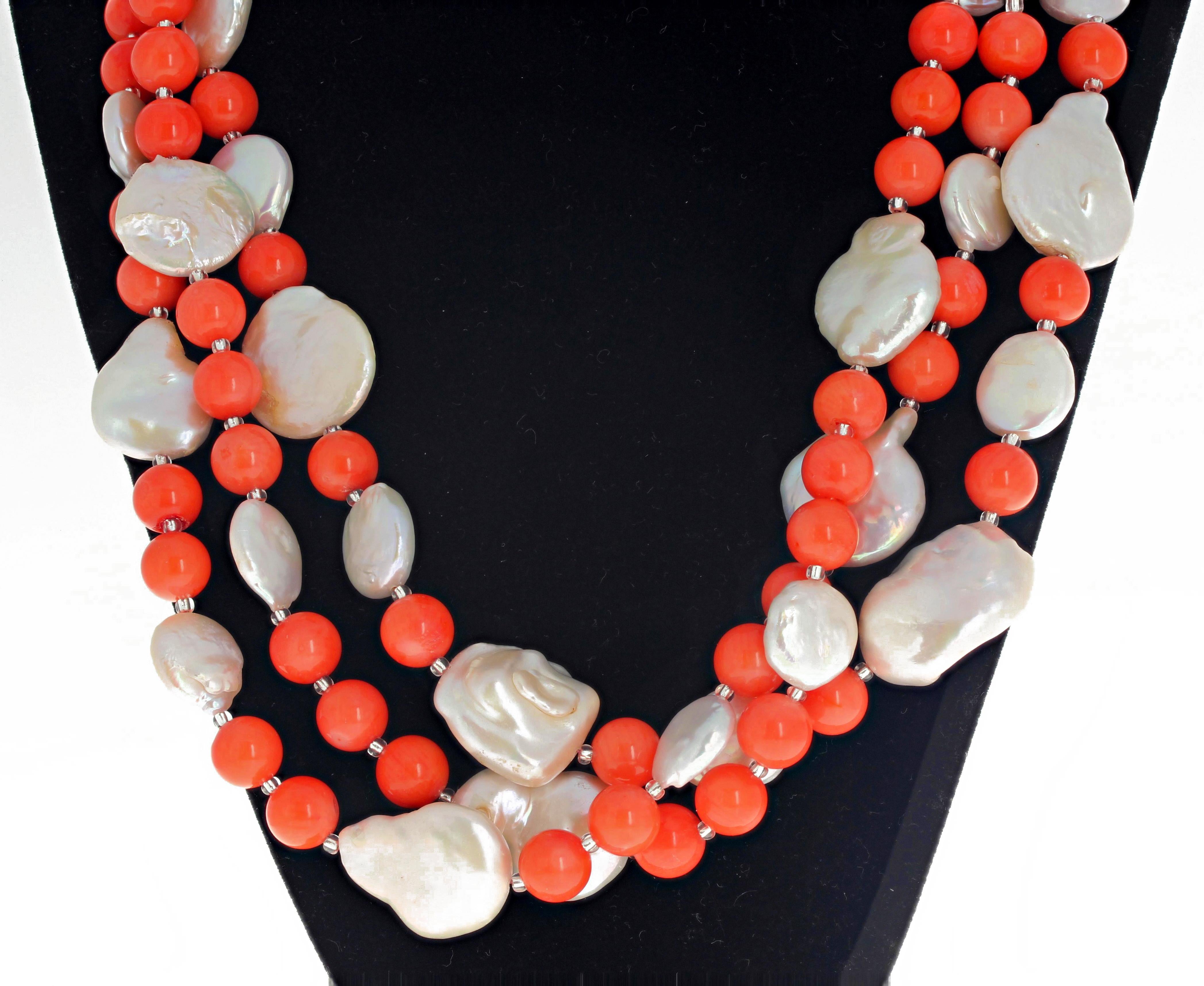 This Gemjunky large three-strand handmade necklace is elegantly designed with round polished real orange coral enhanced with roundish white coin pearls and little Czech sparkles set with an easy to use hook type clasp and is 20 inches long.  The