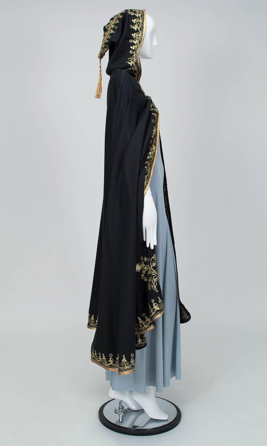 Feeling a little Scheherazade? With its gold ribbon embroidery and full hood, this splendid cape reeks of drama and royalty yet remains light enough to flutter open behind you when you walk. Sigh.

Vintage hooded ankle-length cloak featuring