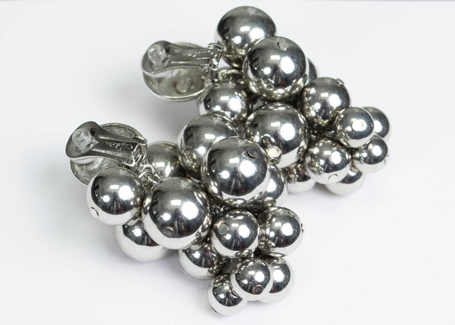 Statement-making earrings that act like spherical mirrors of all different sizes. Dramatically oversized, they resemble clusters of silver grapes and provide brilliant shine.

Clip back earrings featuring a half-round button above a cluster of 15
