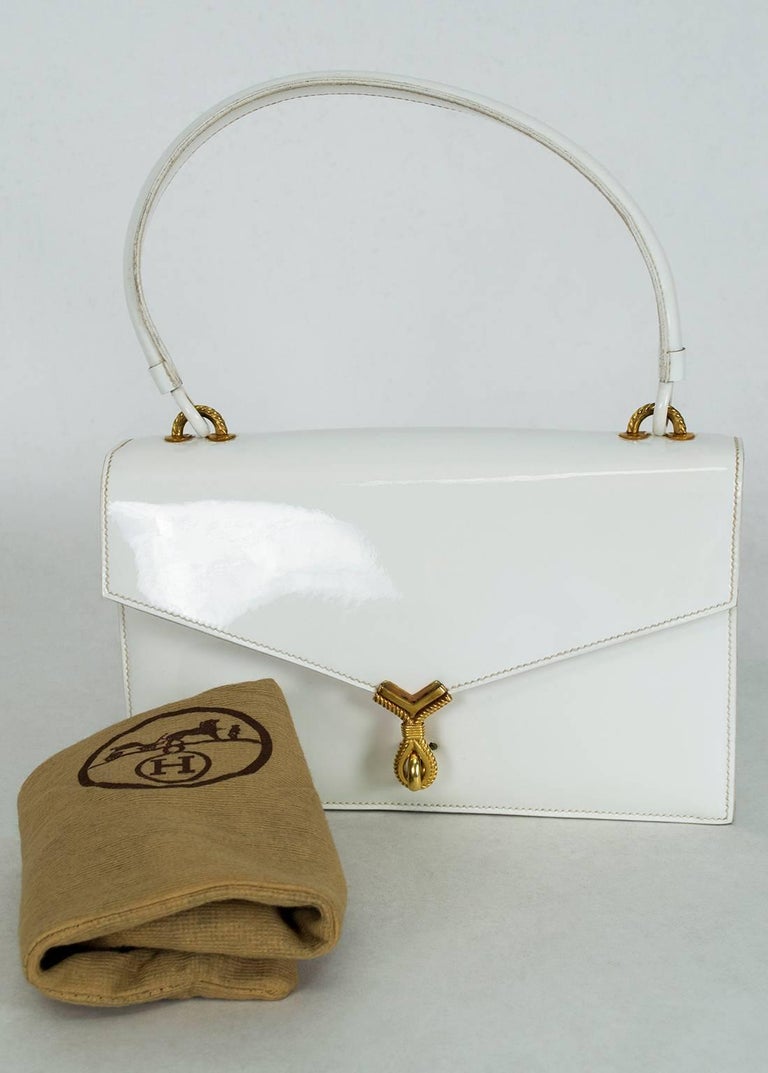 Though it is almost 70 years old, this magnificent handbag is as lustrous and stylish as the day it was made in 1951. Best of all it is true, bright white and an ideal complement to your resort, spring and summer wardrobe.

Envelope-style top handle
