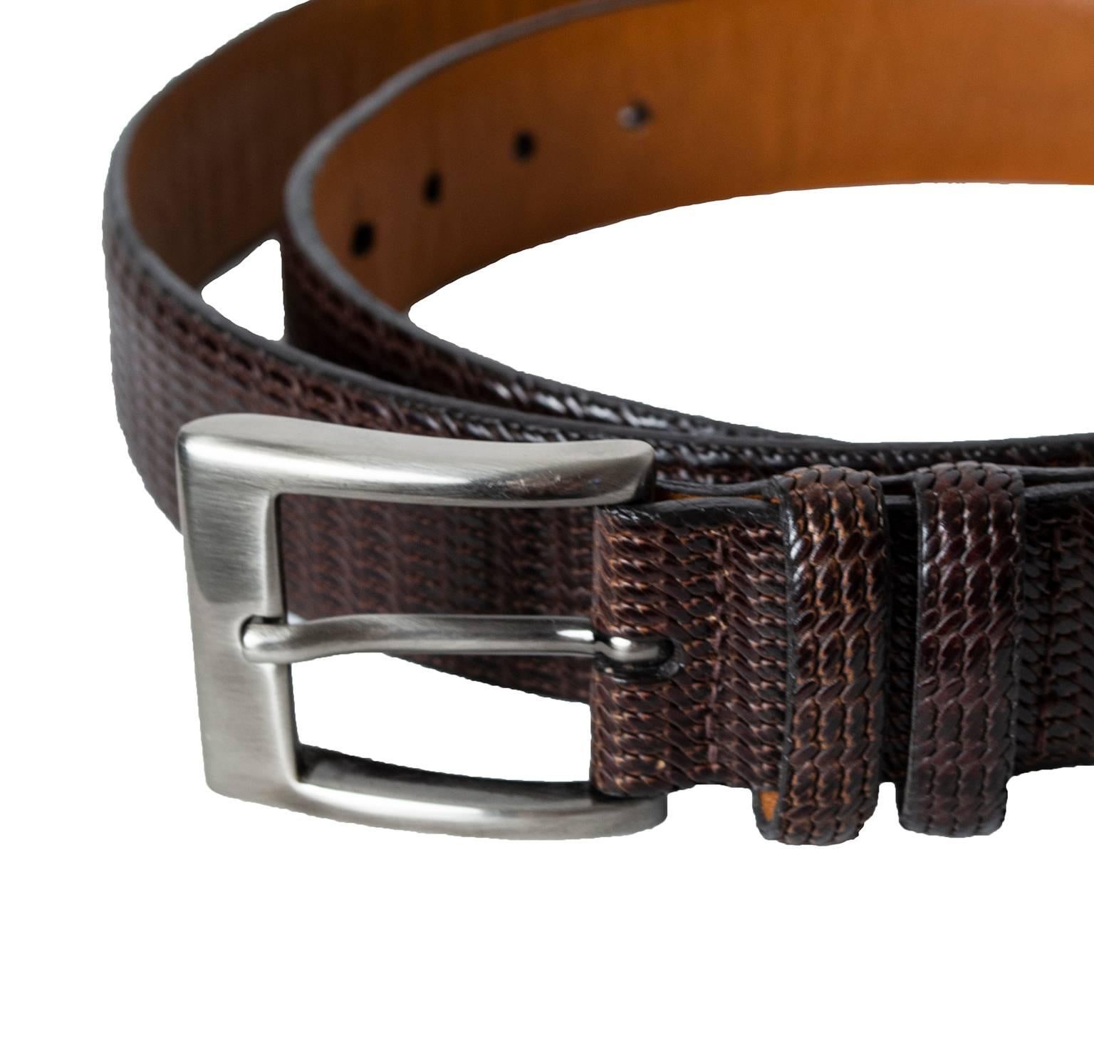 Though it appears to be woven straw—or even lizard skin—this beautifully-textured belt is actually a single piece of finely-embossed leather. Its rich mahogany brown color is elegantly offset by the substantial brushed silver buckle.

Textured