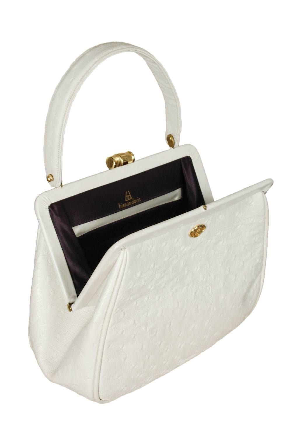 Like the bird itself, ostrich skin is tough and lends itself well to crisply-structured handbags. This one--with its ultra-bright white color, geometric shape and rigid top handle--could not be more perfectly suited to its material, as it maintains