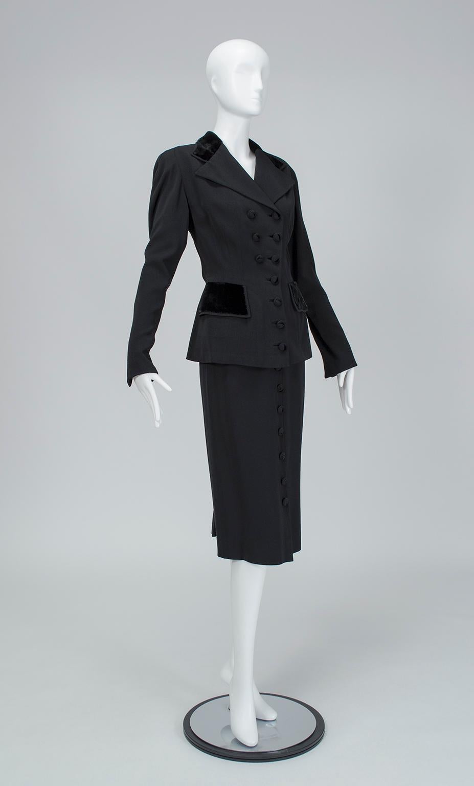 Mit seiner doppelreihigen Jacke, dem knieumspielenden Rock, den vielen Knöpfen und den Samtdetails ist dieser Anzug der Inbegriff des von Rosalind Russell in den 1940er Jahren populär gemachten 