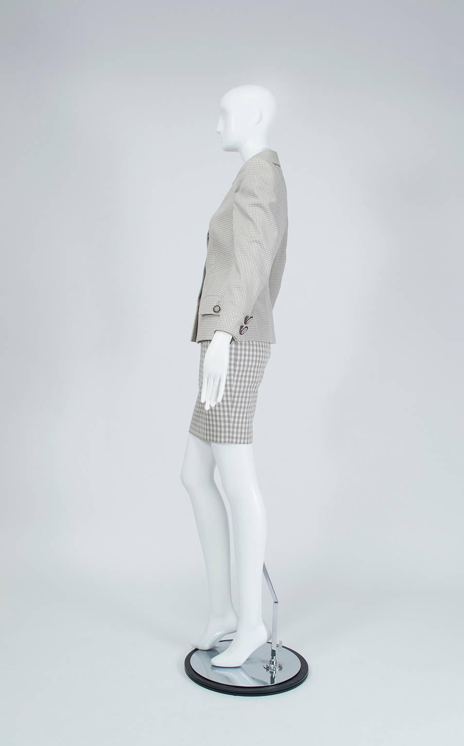 Faisant preuve d'une retenue inhabituelle, Versace a produit ce costume discret qui se boutonne jusqu'à la gorge vers la fin de sa trop brève carrière. La longueur de la mini-jupe et les boutons emblématiques de la Méduse sont les seules allusions