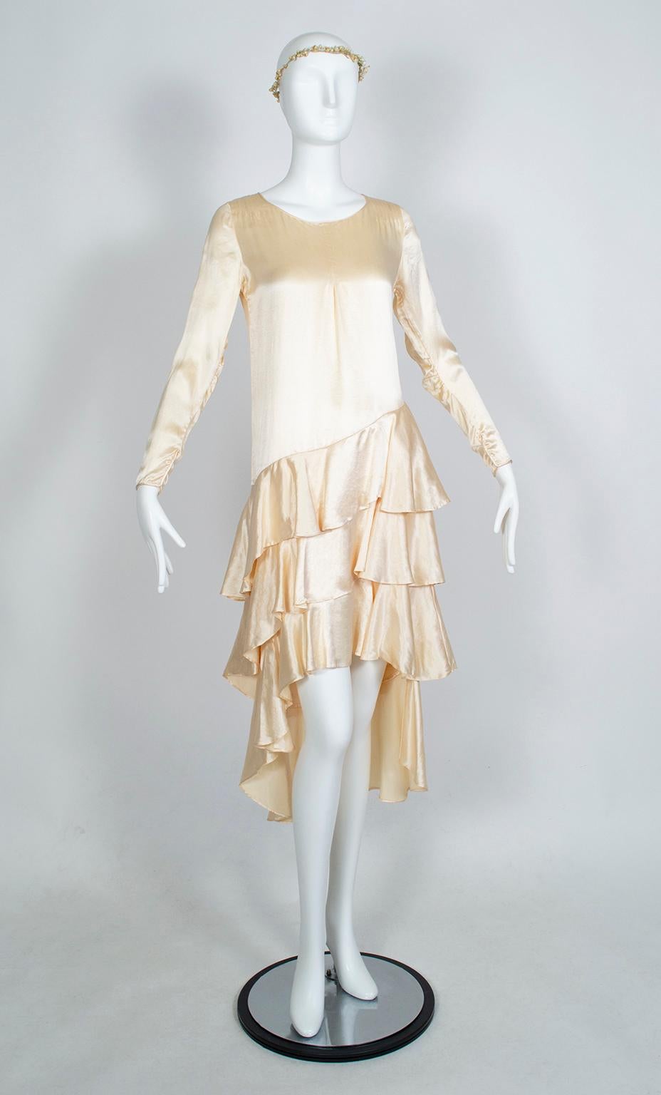A flapper fashionista’s dream, this wedding dress prevents a bride from having to choose between a short or long hemline: it has both! Over a foot longer in the back than at the front, the skirt is made even more interesting because of its multiple