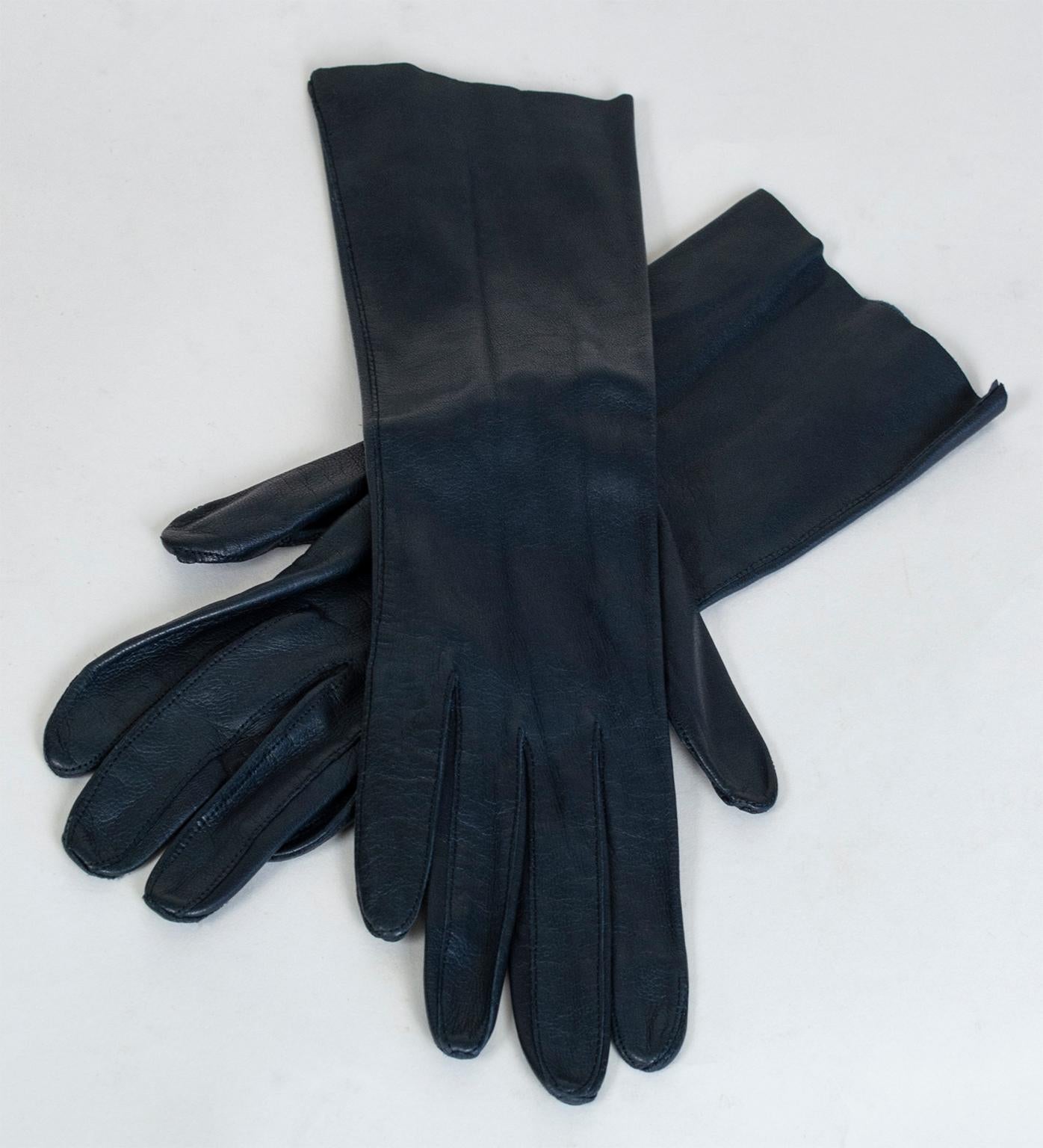 An easy way to elevate the sophistication of any outfit, the right gloves can be both beautiful and functional. In hard-to-find dark navy kidskin leather, this pair fits like a second skin and terminates at the middle forearm, making them ideal for