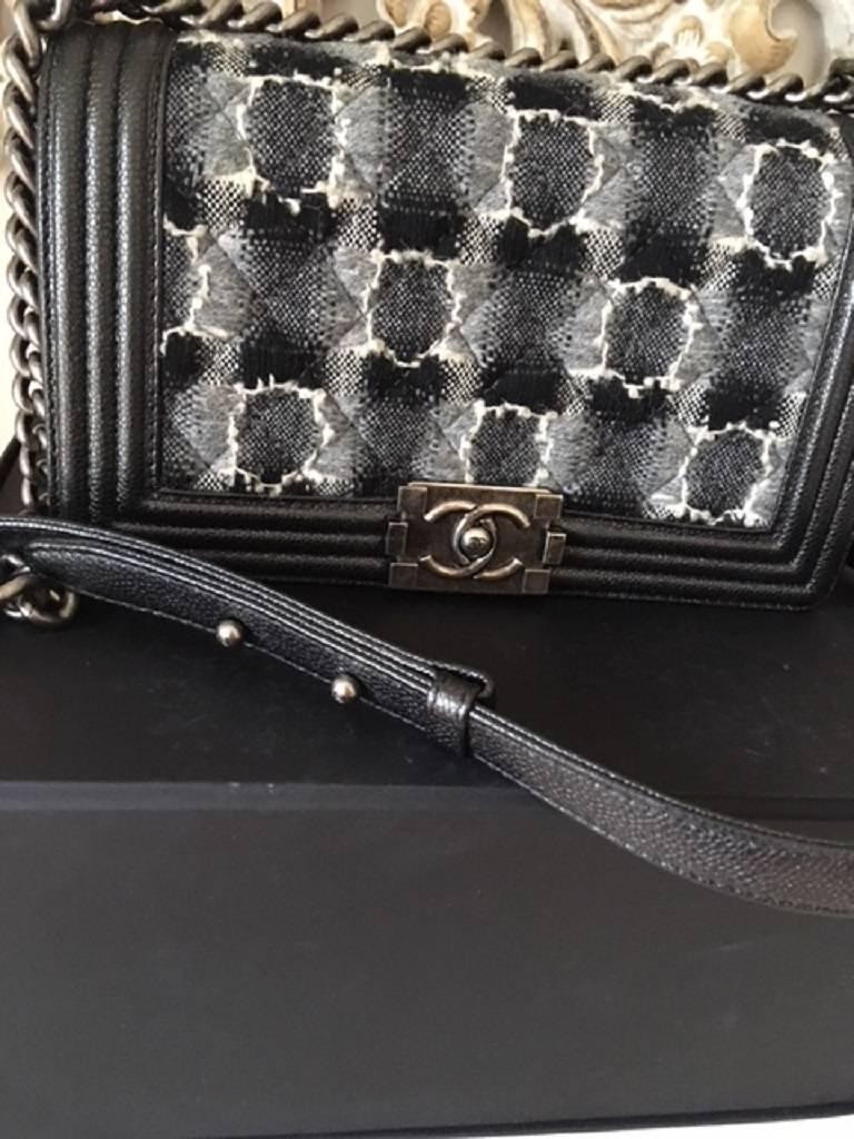 This gorgeous boy bag features the tweed gray caviar leather . It is the medium size and has the silver tone hardware.
The bag has 1 internal pocket and on the outside is the CHANEL CC lock closure. 
The chain handles can be worn as a single or as a