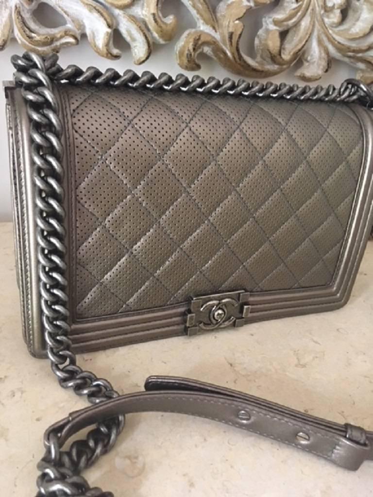 Chanel New Medium Boy in the stunning quilted Lambskin Leather in the perforated metallic bronze colour. 
100% Authentic verified by Lollipuff and comes with a certificate of Authenticity. 
The bag has great storage space inside with a zippered