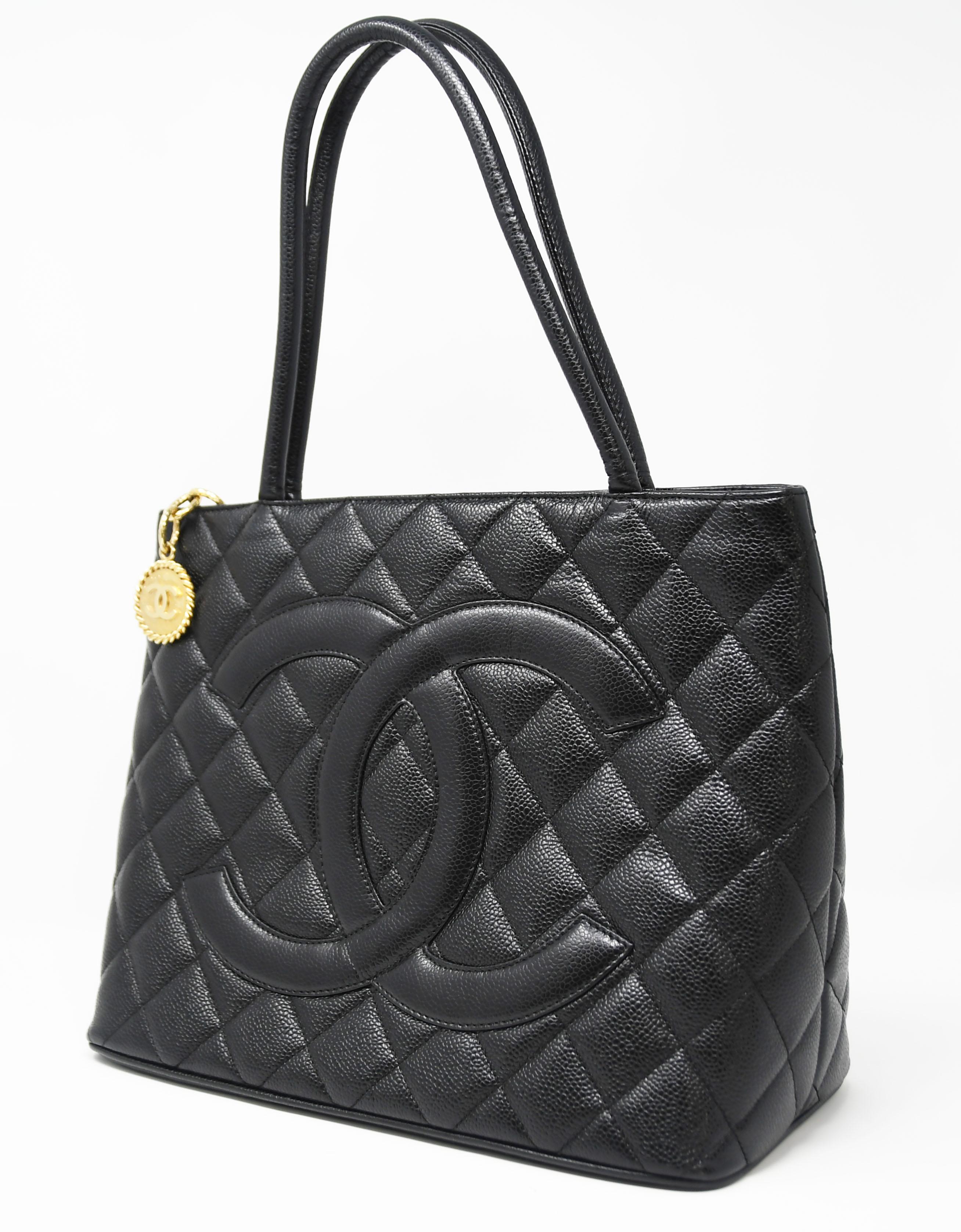 Black classic caviar top handle bag with gold medallion zipper.  Features quilted caviar leather with large 