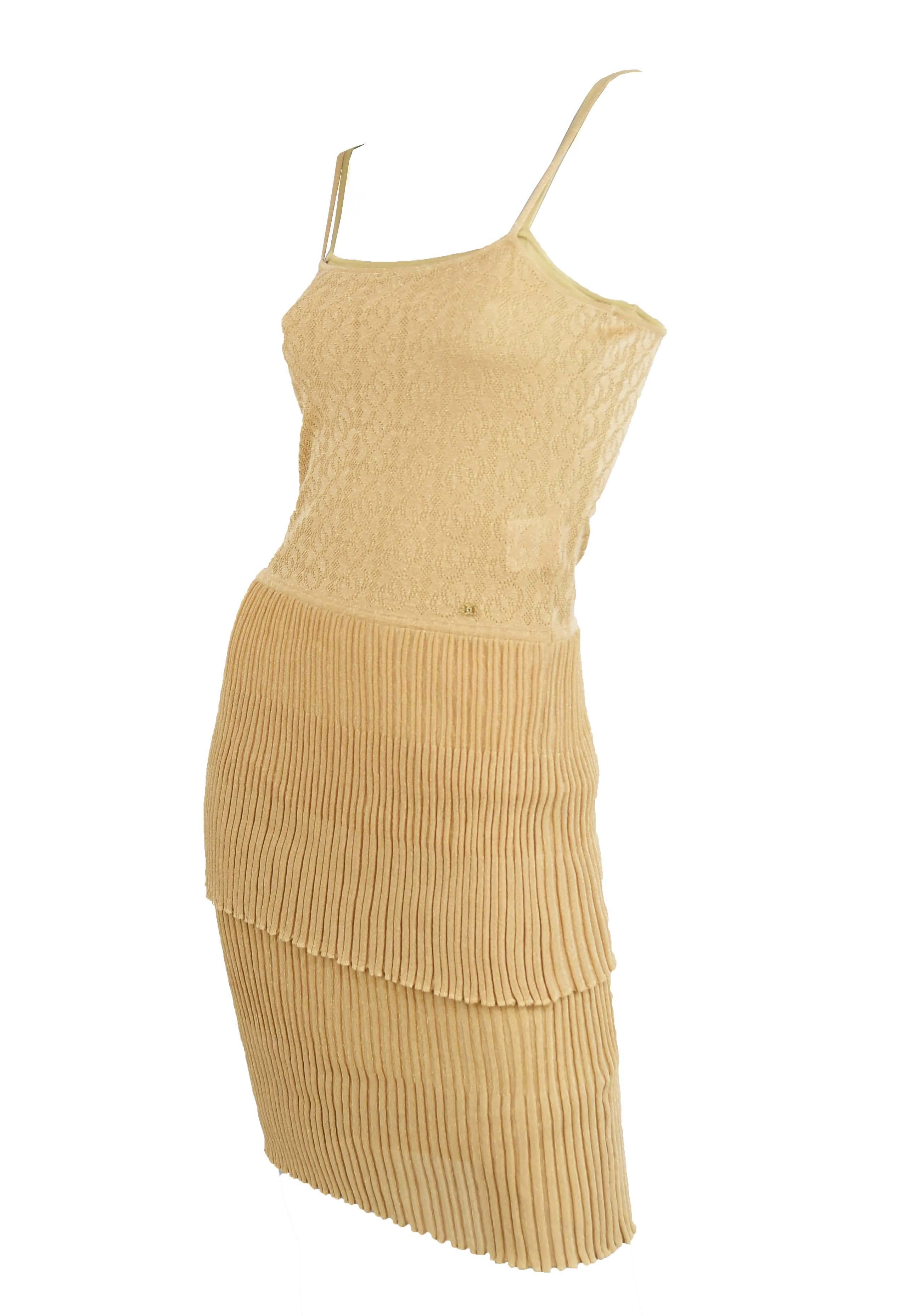 Chanel gold knit spaghetti strap dress with two tiers of beautiful pleating.  Jeweled Chanel logo sewn into the bodice.

Size: FR 36

Condition: Pristine condition

Composition: 80% rayon, 20% polyester / (lining) 100% rayon

Care: Dry clean