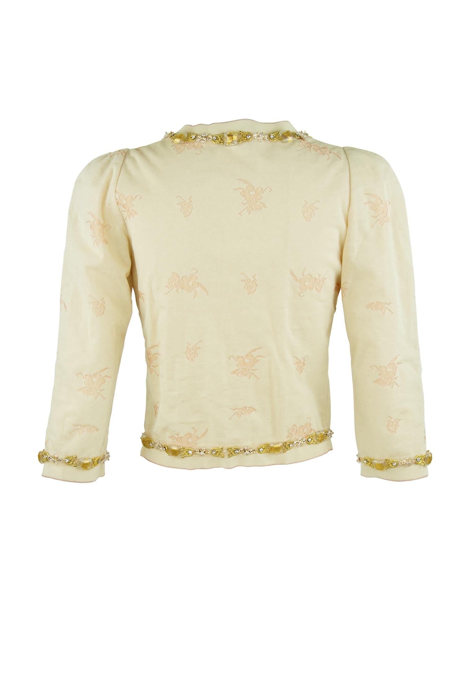 Stunning  light peach jacquard knit cardigan with floral detail.  A gold embellished boarder adorns this sweater and makes it the perfect compliment to a beautiful pair of dress pants or skirt.  Would also look great styled with jeans.  

Size: FR