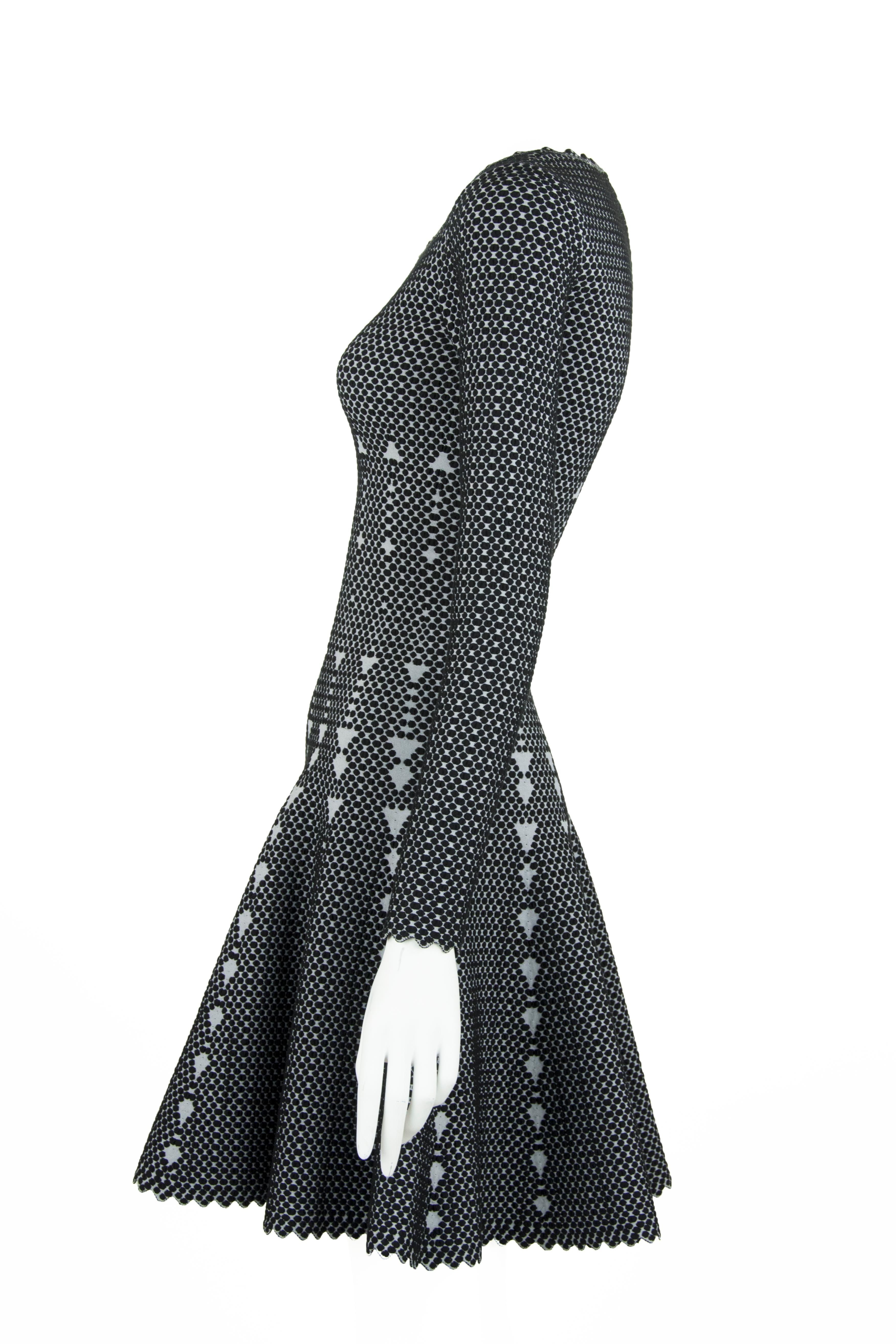 Classic Alaia fit and flare dress in a stunning knit jacquard fabric that is composed of black and gray dots.  Features a square neckline with a delicate scalloped finish on the edges.  Very flattering silhouette.

Size: FR 36

Condition: Pristine,