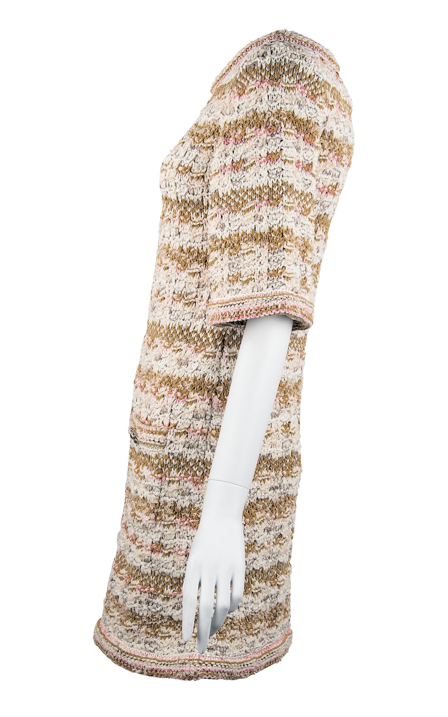 Amazing piece from the Chanel 2015 Resort collection.  Thick woven fabric composed of off white, light pink, beige and metallic knit yarns.  Features half sleeve and two front pockets with decorative silver buttons.

Condition: New with tags

Size: