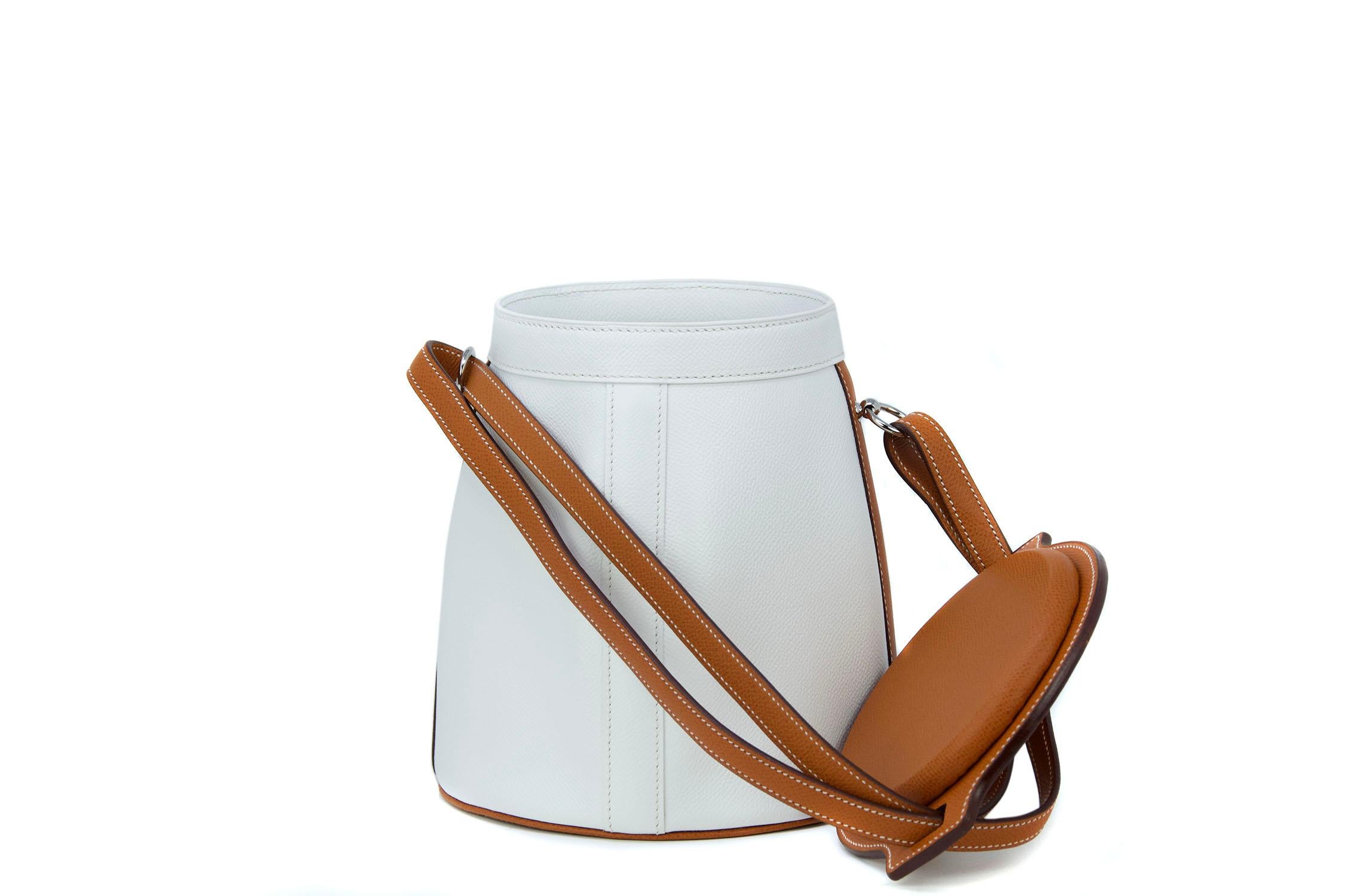 This Hermes farming bag is a truly rare collectors item.  Crisp white epsom leather with the coveted Hermes Barenia leather.  Features adjustable leather strap and palladium hardware. 

Condition: New

Measurements:
Diameter Top 14cm / 5.5