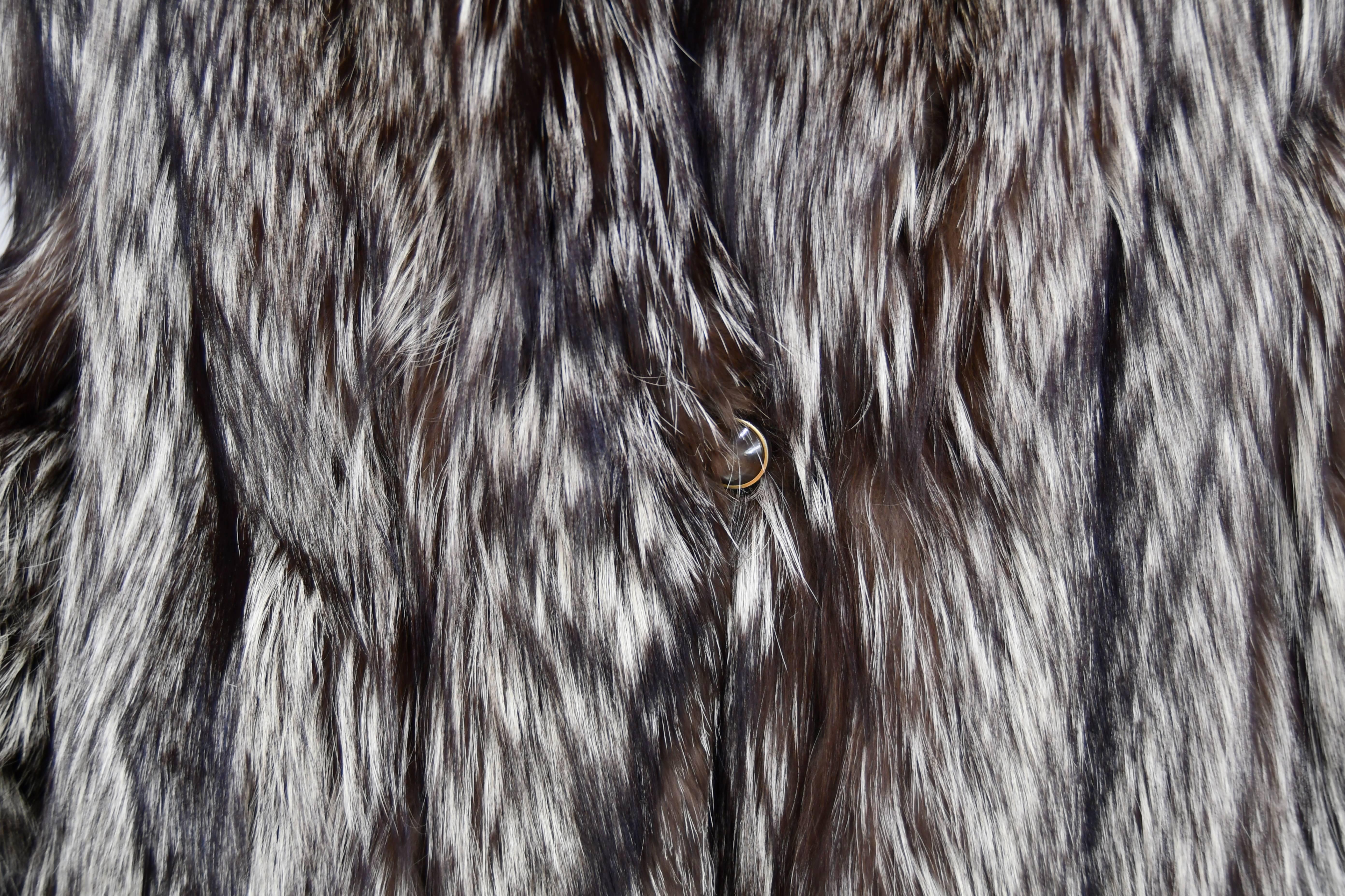 Silver Fox Fur Coat genuine high quality fur coat with rich and beautiful long hair.  Wearing this coat will be the essence of sophistication.  It has an lovely shawl collar wrapping you in an elegant designed Stroller style. Two slit side pockets