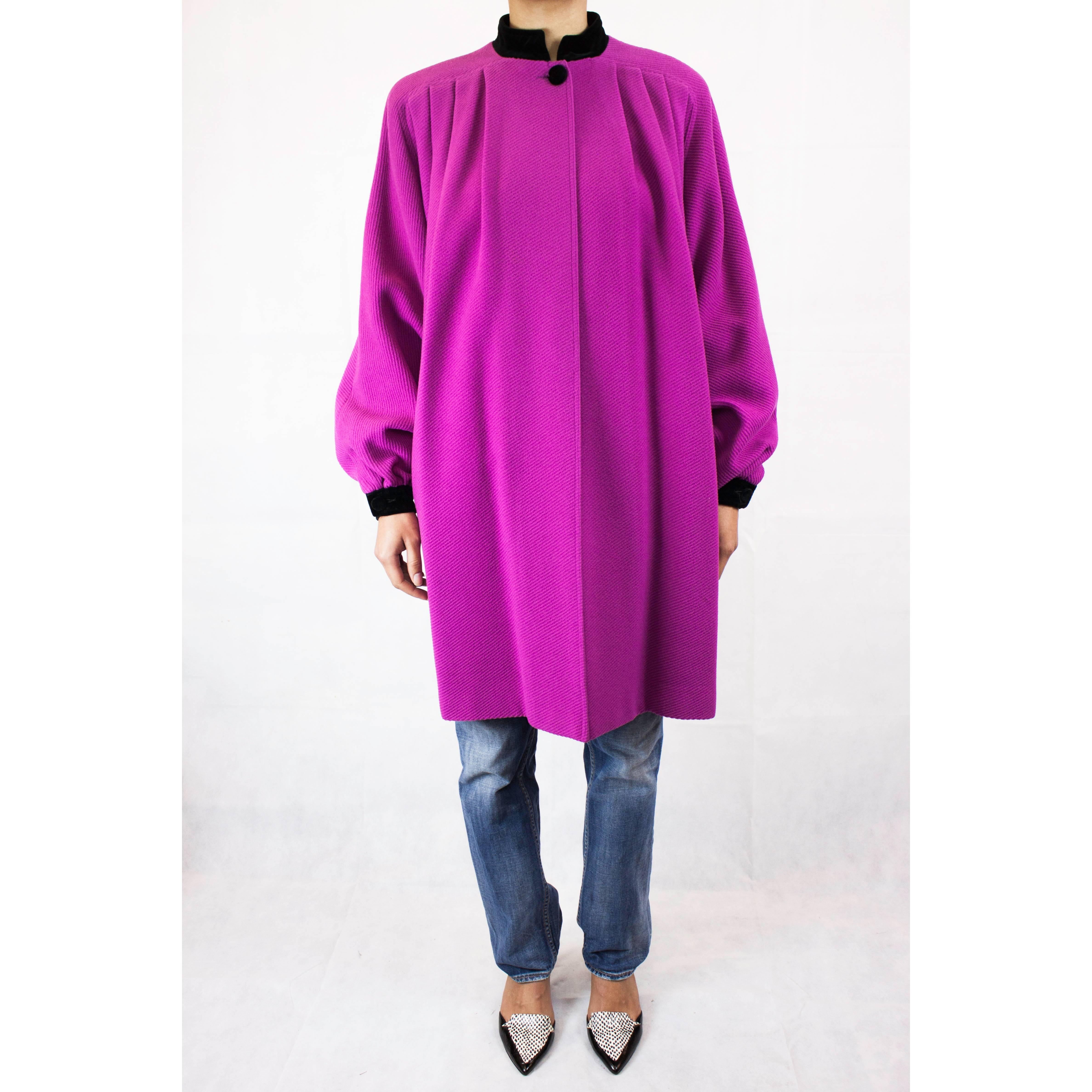 This Valentino coat is constructed from pink cable ribbed wool cloth. It has a flattering swing cut and would be a wonderful option for evenings.
 Featuring a black cotton velvet standing collar, with pleats from the shoulders to the front and back.