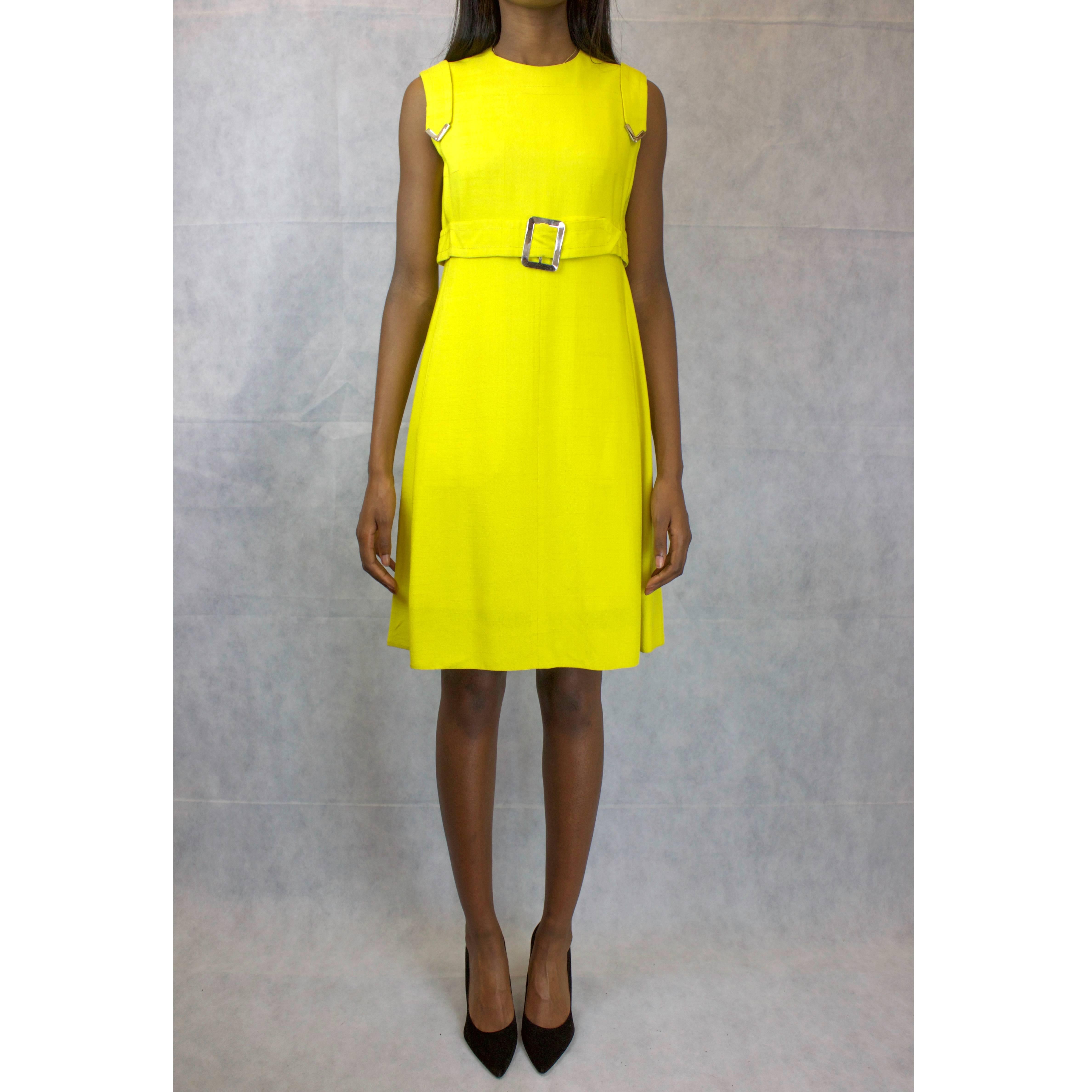This vibrant Ted Lapidus couture-finished dress No: 21853 is a French take on the fashion that characterised London Mod subculture of the 1960s.

An A-line shift dress made from linen in the flamboyant yellow of the era. The metal buckle on the