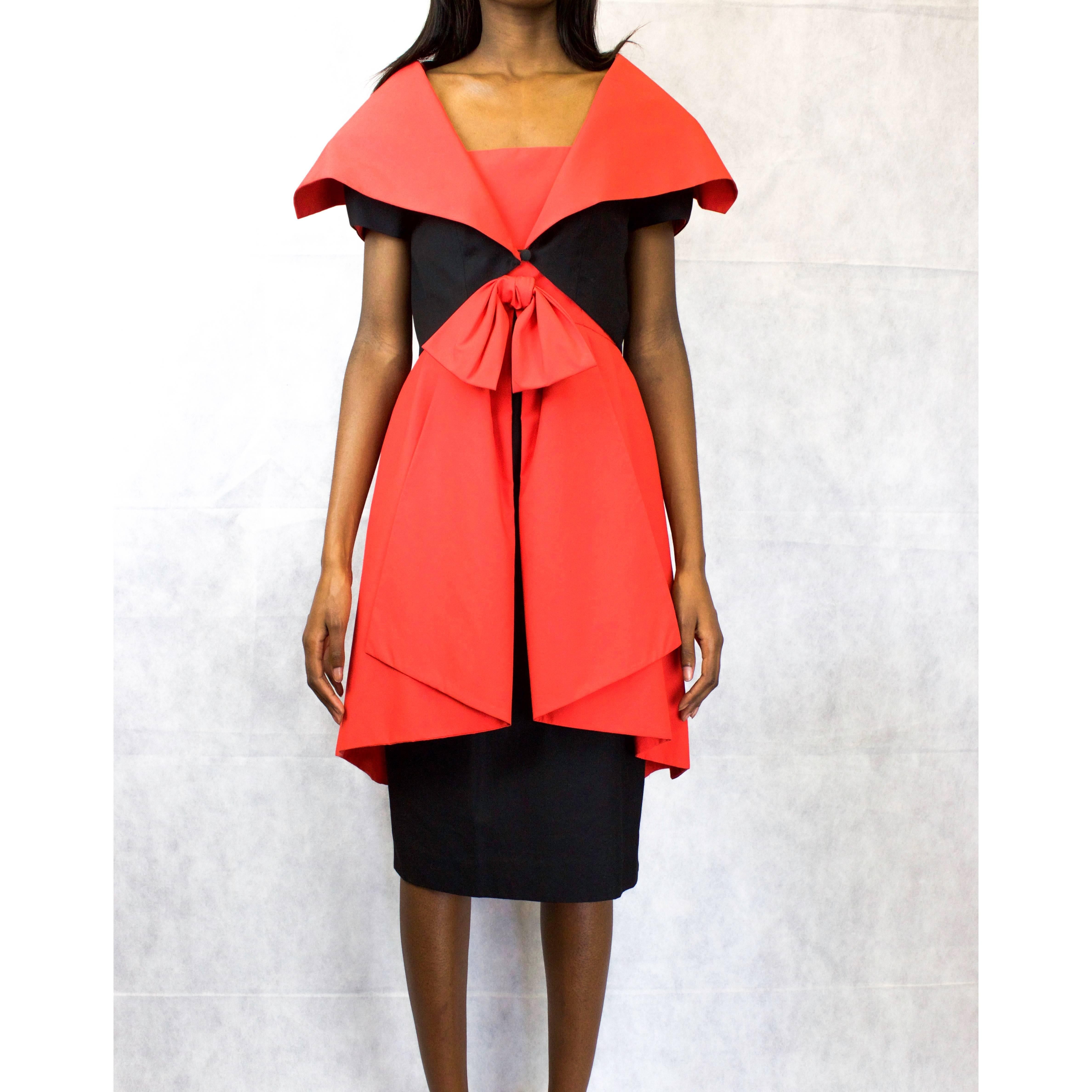 A beautiful and delicately constructed ensemble made from bi-color cotton. The dress features a fitted bodice with fine straps and adorned with a bow under the bustline. This black slim fitted dress is folded within a flared orange origami style