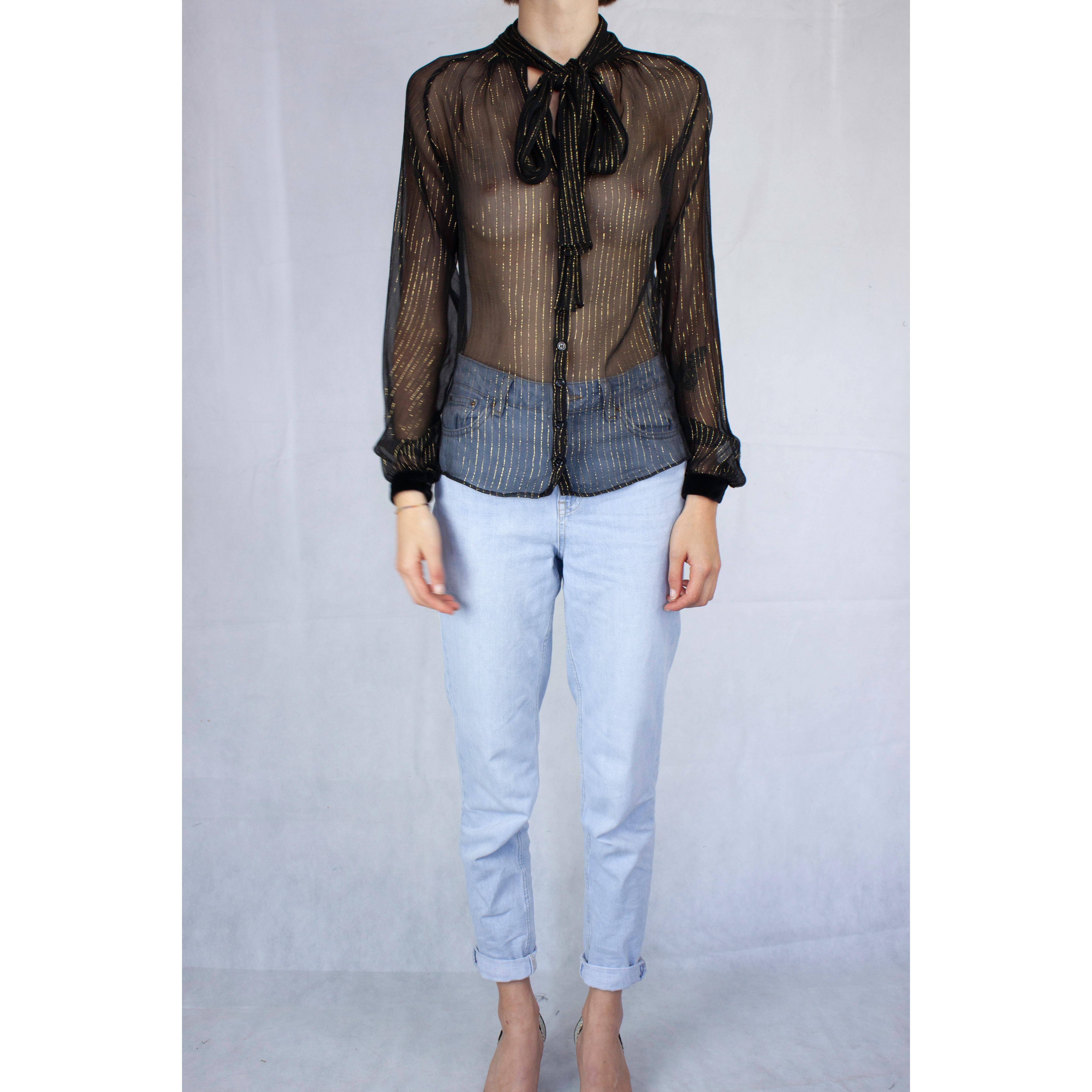 
This classic paper-thin blouse by the Italian fashion duo is constructed from a silk chiffon material adorned with delicate gold pin stripes . Featuring long sleeves with silk velvet barrel cuffs. The blouse is set off with a bow at the neckline.