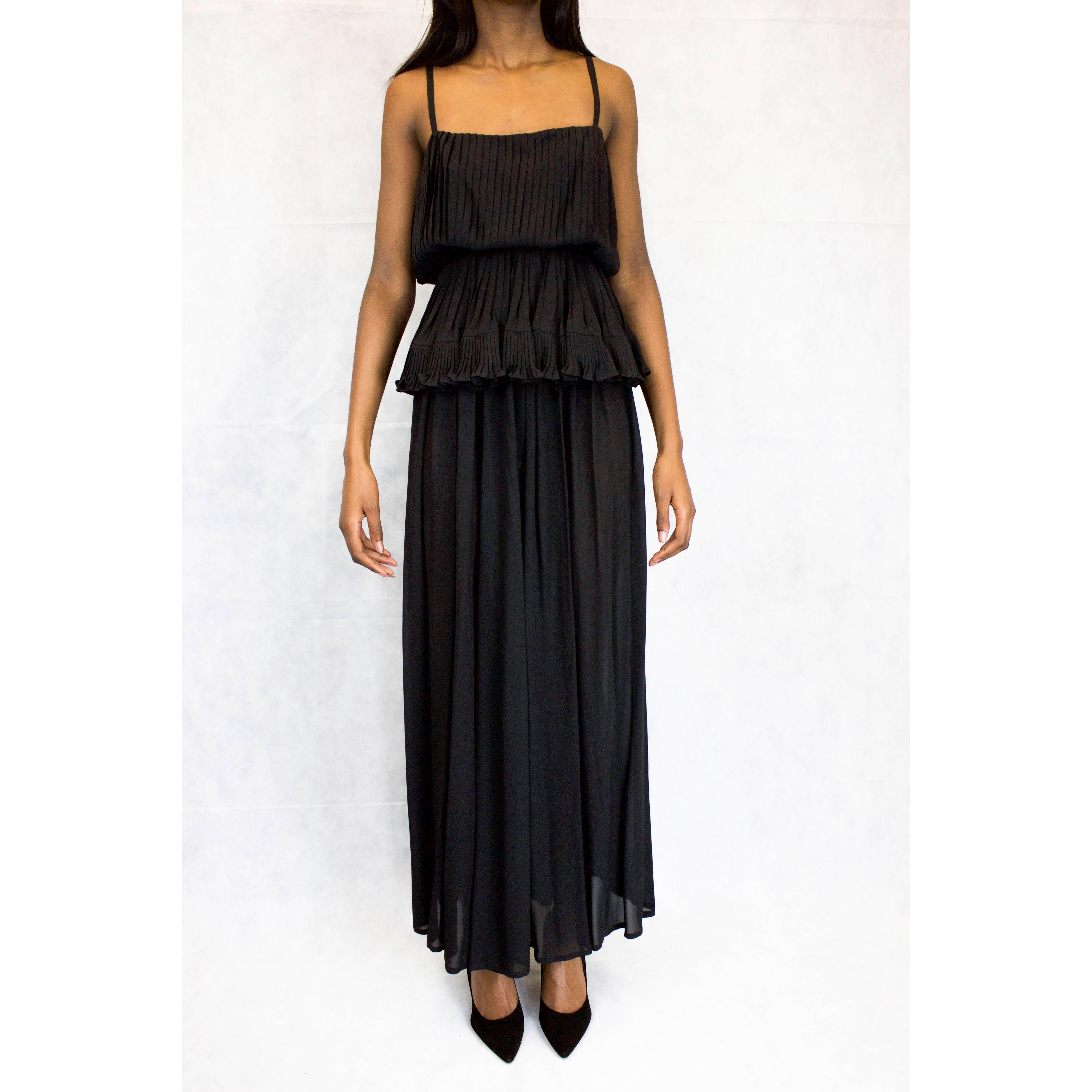 This beautiful 1930s style Schiaparelli ensemble is constructed from black silk chiffon. The top has a ballerina neckline and spaghetti straps and is encased in and framed by small hand pleats that cinch in then flare out at the waist. The full