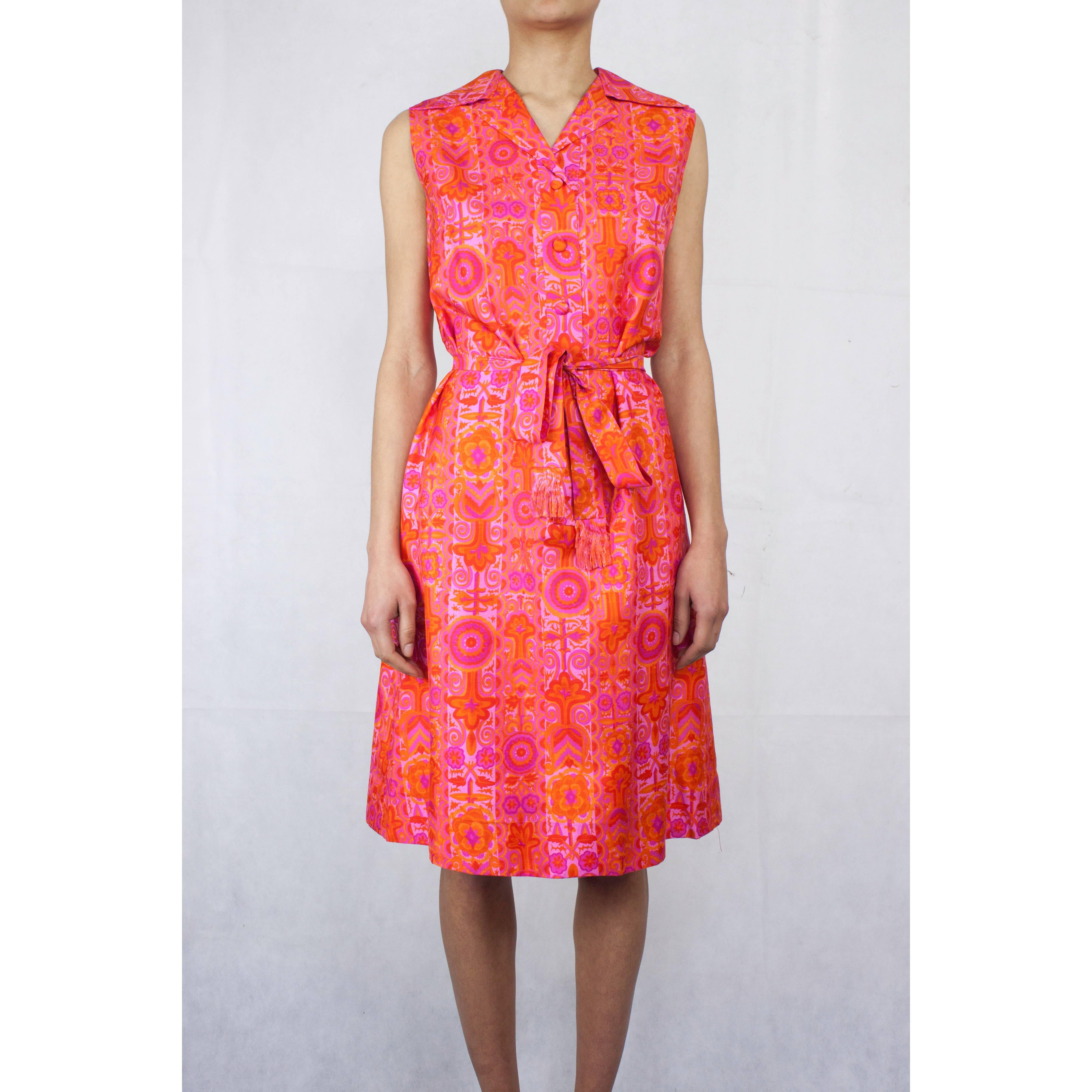 
This couture finished dress is constructed from a luxurious silk material from the Lyon silk weaver Bianchini-Férier. Featuring a fuchsia, orange and saffron floral motif, small notched collar and single-breasted with silk covered buttons at the