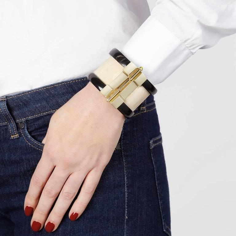 Bespoke cuff bracelet crafted by hand from jacaranda wood and African cow horn. The customizable 18k gold plated pin-clasp is set with a choice or ruby, blue sapphire or emerald. Inspired by warrior style cuffs worn by former Vogue editor Diana