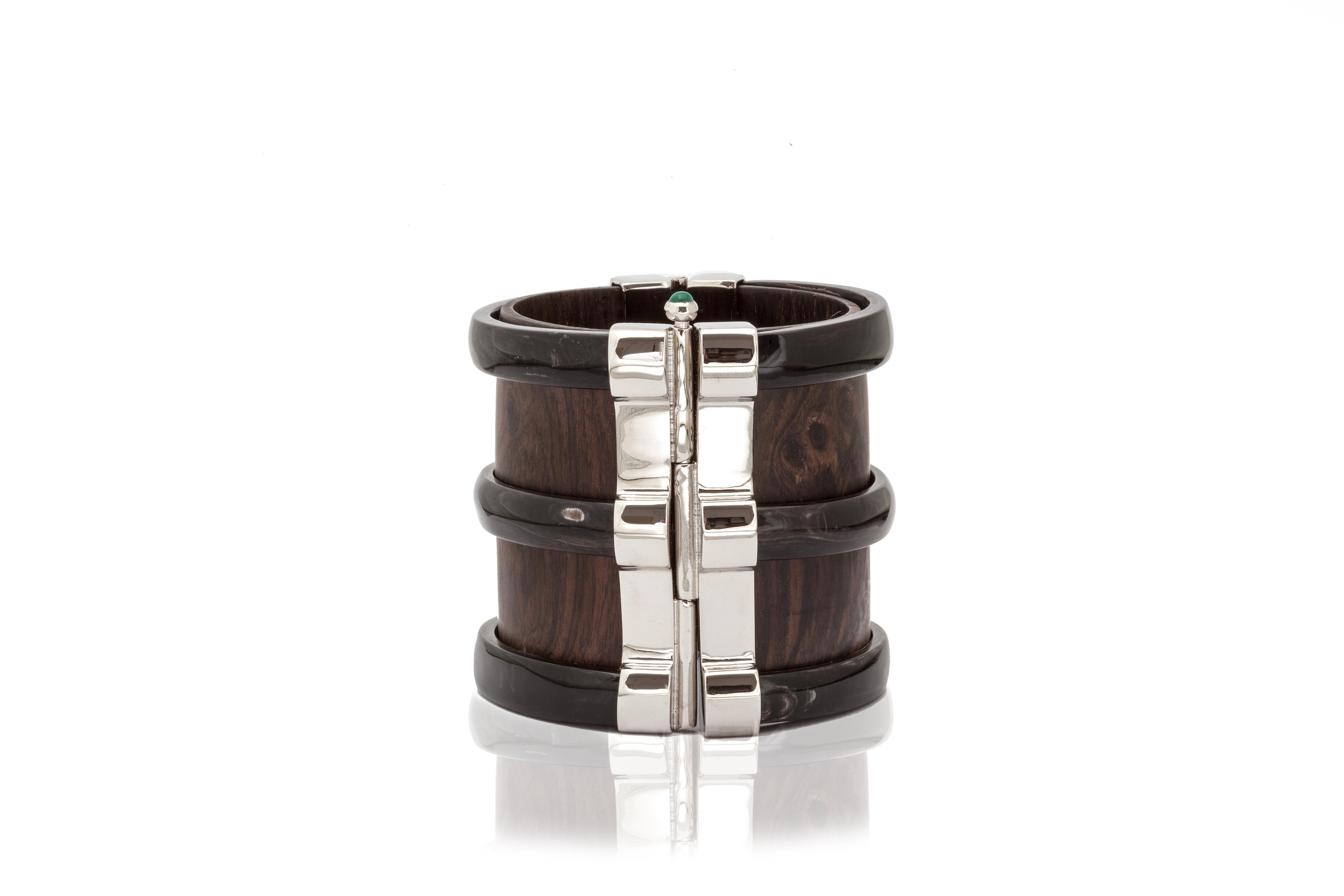 Cuff bracelet crafted from ebony wood and African cow horn. The customisable silver pin-clasp is set with a choice of ruby, sapphire or emerald from conflict-free mines in Zambia. 

Please note that horn inclusions and slight irregularities may