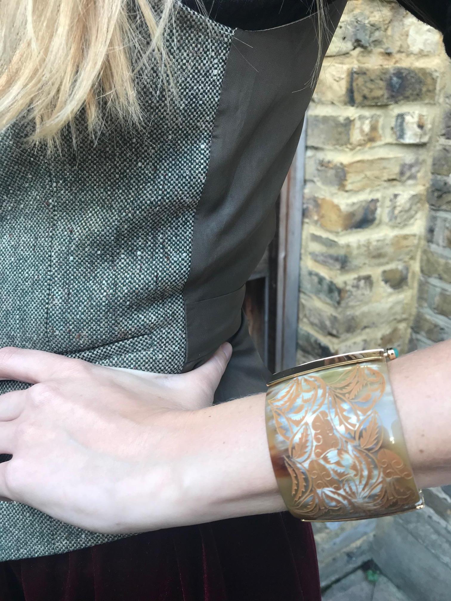 Cuff bracelet made of African cow horn engraved with wild foliage motif. The customisable pin-clasp is set with a choice of fire opal or emerald, sourced from conflict-free mines in Africa. 

Hand crafted by artisans in Kenya, East Africa and