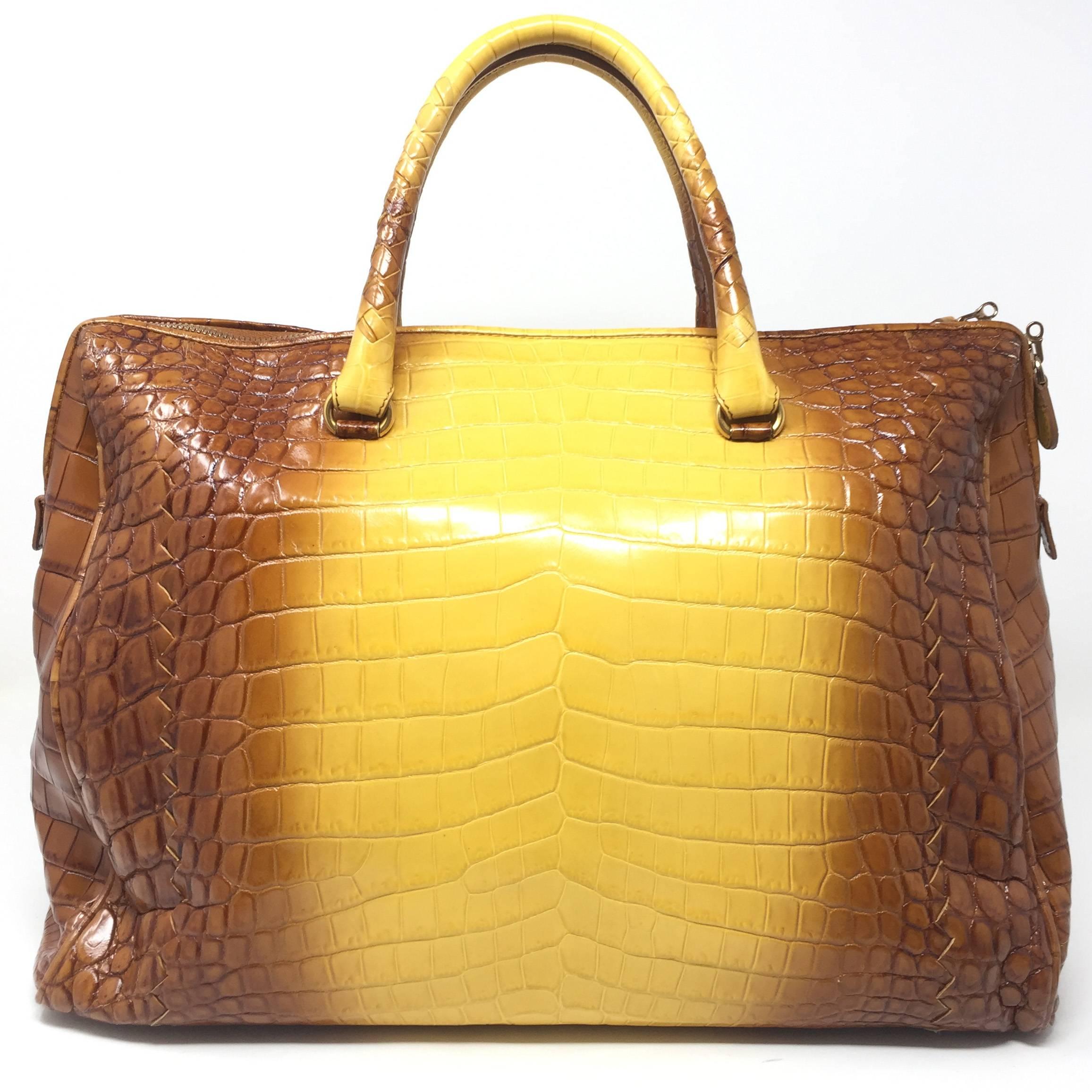 The Cocco Glace Bag by Bottega Veneta is a beautiful bag made of shiny crocodile leather, has an elegant dègradé color that fades from caramel brown to yellow.

The Cocco Glace Bag has double handles and a double zip closure, it also has a padlock