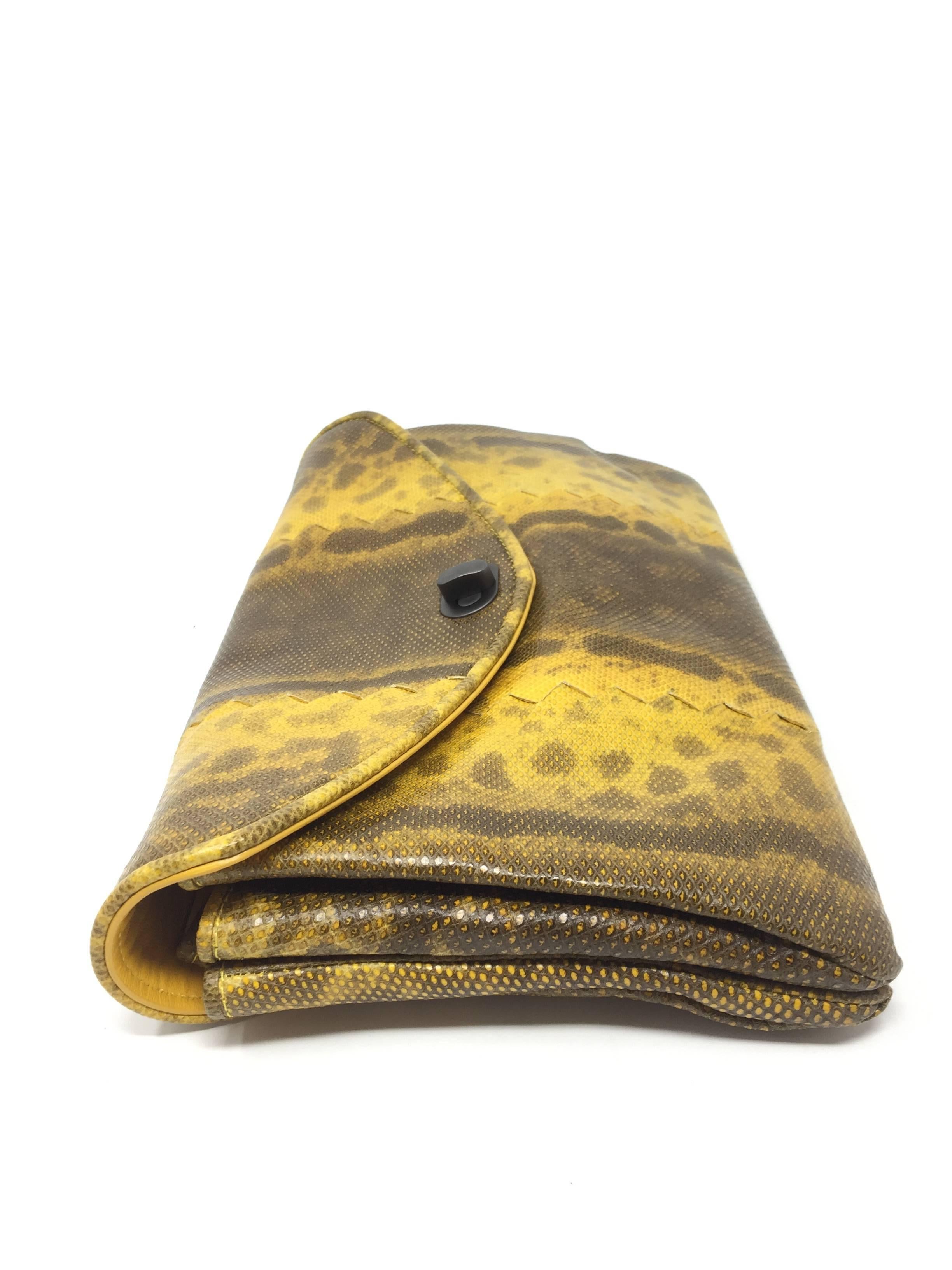 Bottega Veneta mustard yellow lizard clutch featuring woven patchwork design and extendable, accordion body. Turn lock clasp opens up a shared room for storage. Comfortably fits a cellphone, small wallet, and other essentials. 
 
Dimensions cm