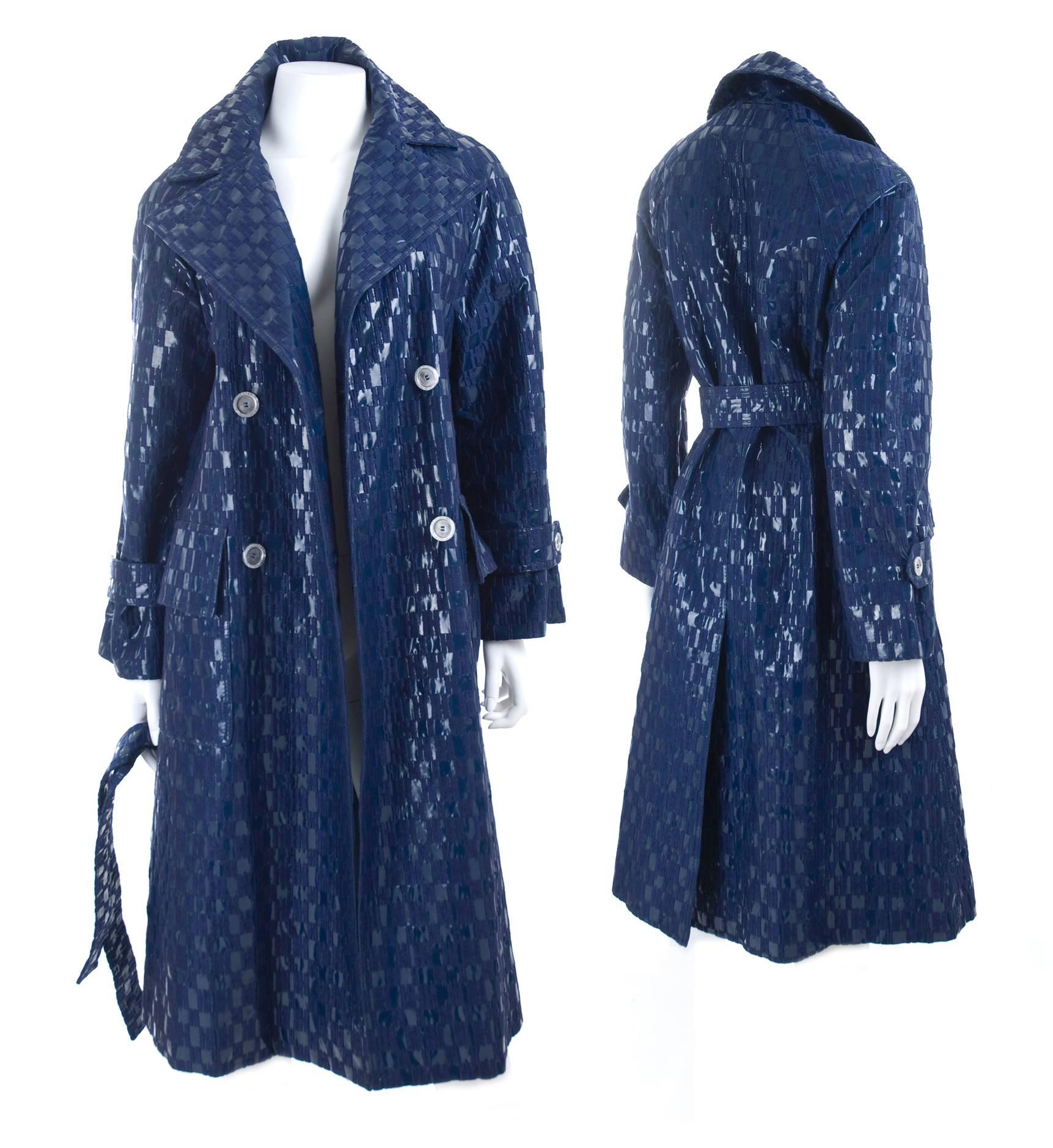 Rare 1960's embroidered monogram rain coat from Hermès Sport. The material is vinyl PVC in deep blue with H monogram embroidery. Double-breasted closure with silver Hermès inscribed buttons. Large flap pockets and belt. 
Excellent, pristine