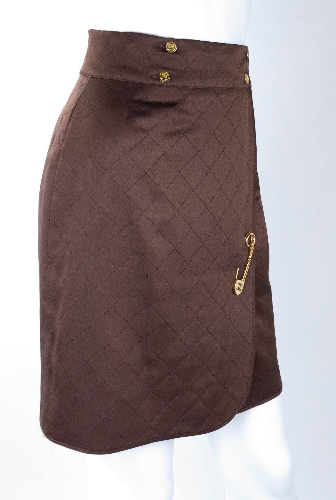 Chanel quilted wrap skirt in brown with CC safety pin.
Circo 1980s
Size label is missing.
The waistband has been extended by a tailor. Please see picture for details.

Measurements:
Length 51 cm -  20