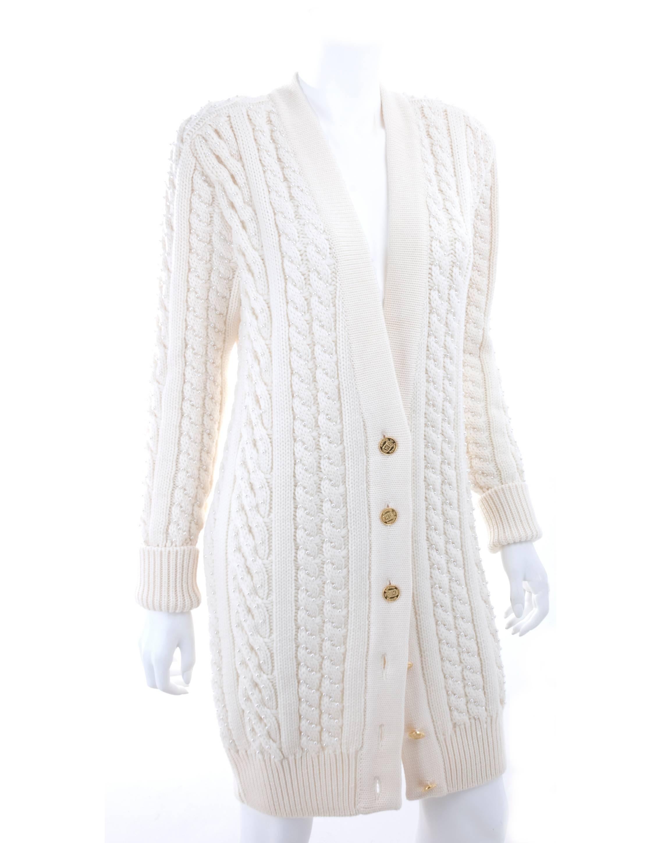 CHANEL pearl encrusted  cable knit cardigan from circa 1990.
Featuring a v-neck, long sleeves, a ribbed hem and cuffs and a button front fastening with gold-tone logo buttons and one extra.
No size label - should be Large.
Excellent condition -
