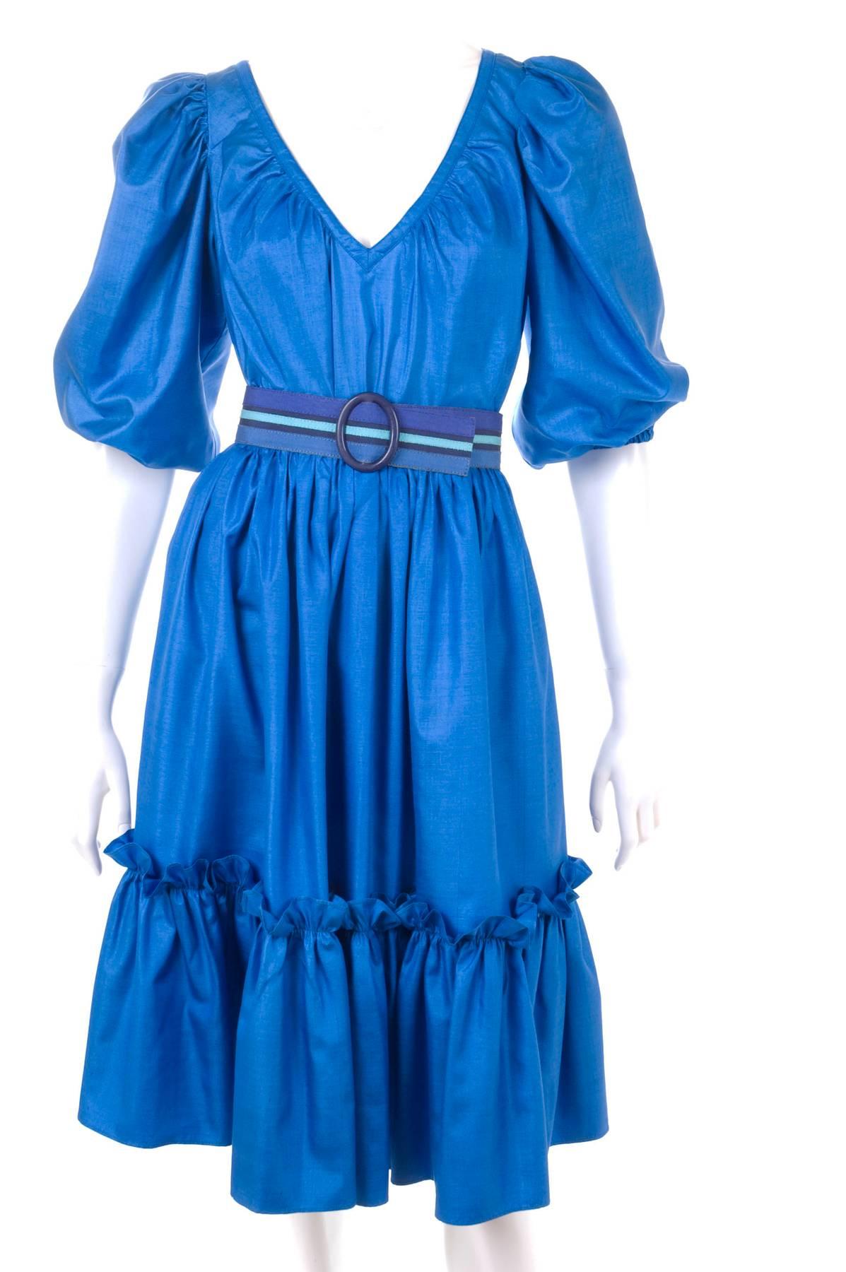 Yves Saint Laurent Vintage early 80's Gypsy Silk Ensemble in Royal-Blue.
The skirt with a ruffle hem line and pockets in the side seams. The blouse in slip-on style with elastic at the sleeves end.
The belt in 3 blue tones made of fabric and leather