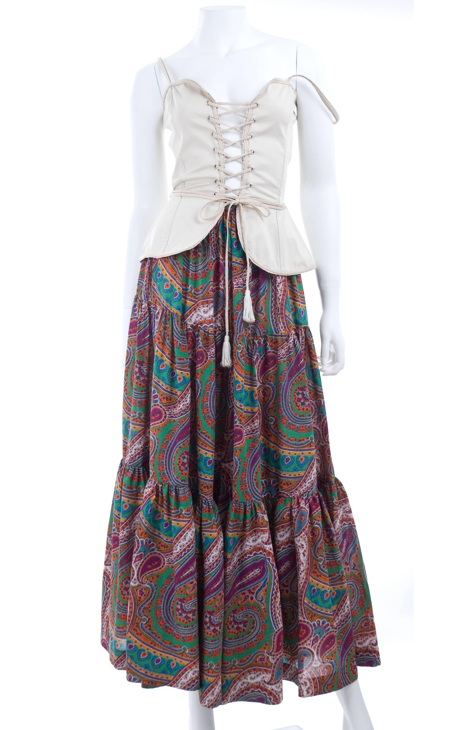 1970 Yves Saint Laurent gypsy skirt and corset top. The skirt in a colorful print and the bustier in creme.
Size 38 EU  
Measurements:
Skirt: length 39 - waist 26 inches
Bustier fits best for bust 34 inches