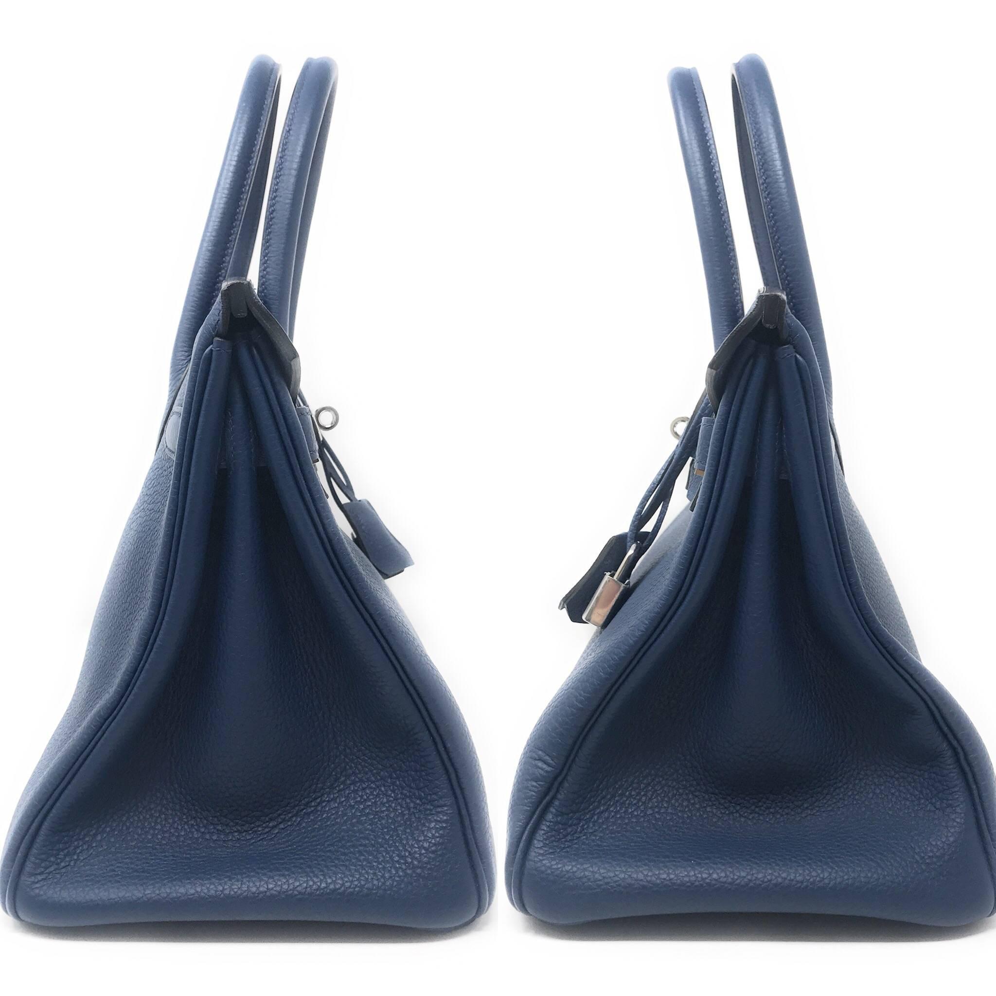 One of the most unattainable handbags, the Hermes Birkin bag in 30cm is a size that can be enjoyed day or night. This particular one is crafted in Navy Blue Togo leather with tonal stitching, dual tubular handles, and a flap closure. It is accented