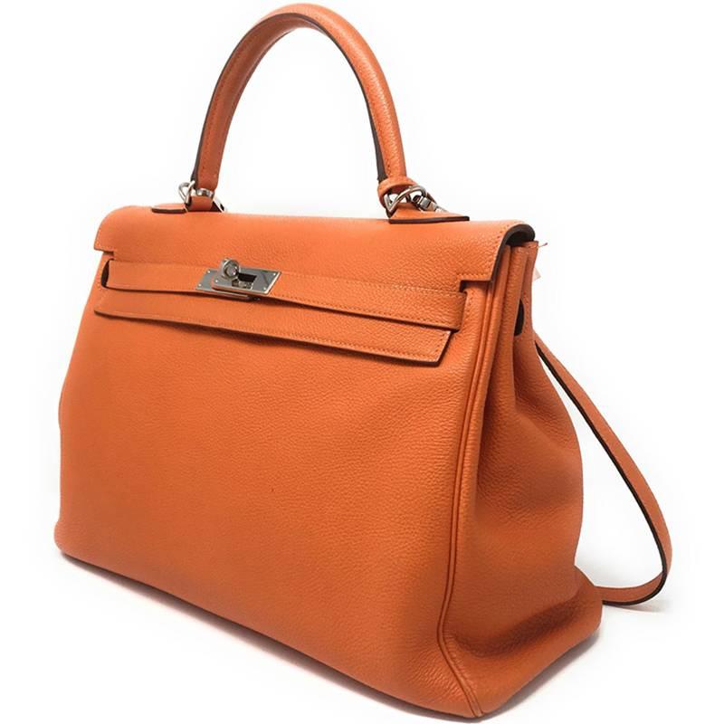 The beautifully bright Hermes Tangerine Orange. 
This iconic Kelly bag is crafted in the Retourne style of Togo leather, and accented with Palladium hardware. It has one top handle and a detachable shoulder strap for versatility. 
This is the 35cm