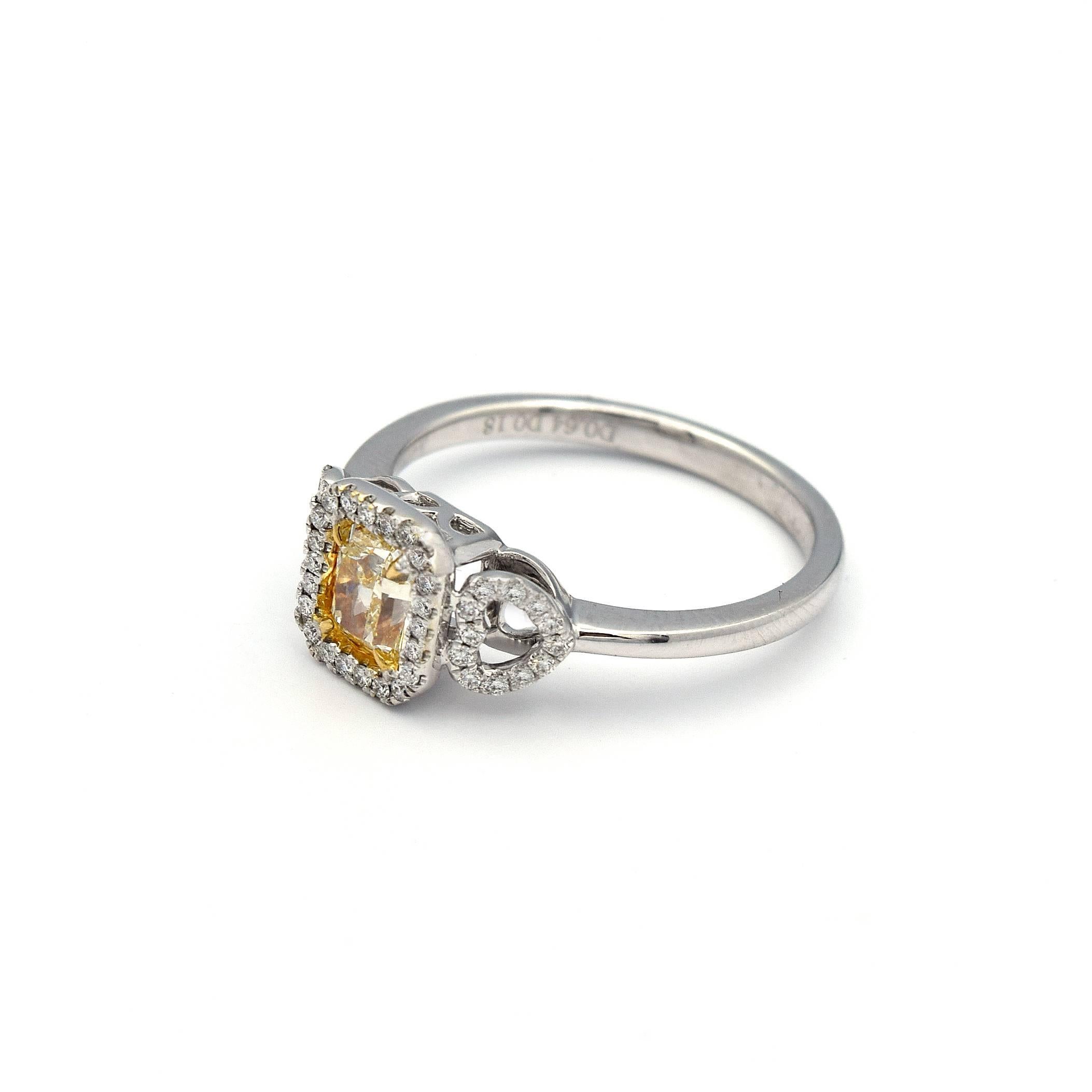 This charming .64ct Radiant cut Natural Yellow Diamond Ring, has a beautiful mount, that has 2 heart shapes to the side paved with White Diamonds. Give it a delicate yet chic look.

45 White pave diamonds weight approximately 0.18ct.

The ring is