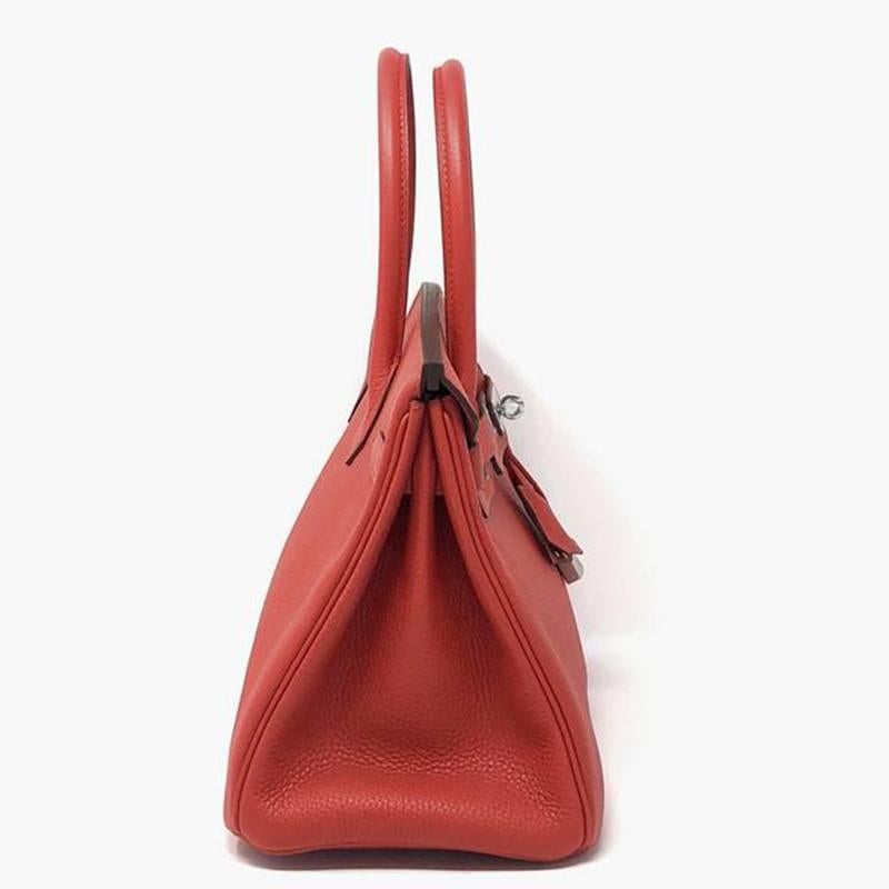 The fresh and bright Hermes Rouge Tomate is the color of this Birkin handbag, named after Jane Birkin who collaborated on its design in the mid eighties.
 It is crafted in Clemence leather in one of the most sought after sizes, which is 30cm. It has